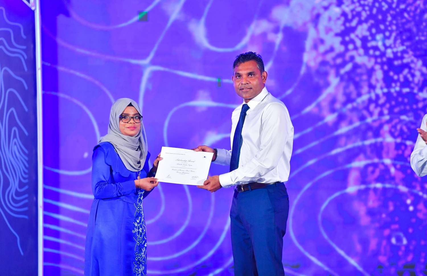 މާލެ: ޑިސެމްބަރު 19، 2021: އެމްޓީސީސީގެ 41 ވަނަ އަހަރީ ދުވަސް ފާހަގަކުރަން ބޭއްވި ޖަލްސާގައި، މި އަހަރުގެ މުވައްޒަފުން ތަމްރީންކުރުމުގެ ޕްރޮގްރާމަށް ހޮވިފައިވާ މުވައްޒަފަކަށް ނައިބު ރައީސް ފައިސަލް ނަސީމް(ކ) ލިޔުން ހަވާލު ކުރައްވަނީ.-- ފޮޓޯ: ރައީސް އޮފީސް