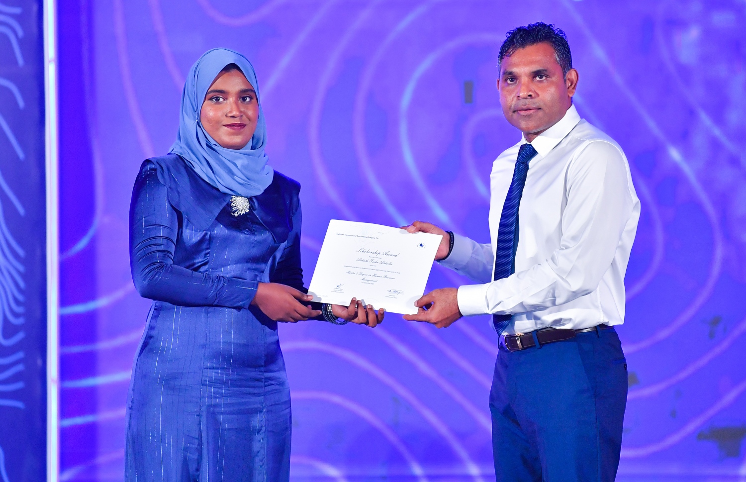 މާލެ: ޑިސެމްބަރު 19، 2021: އެމްޓީސީސީގެ 41 ވަނަ އަހަރީ ދުވަސް ފާހަގަކުރަން ބޭއްވި ޖަލްސާގައި، މި އަހަރުގެ މުވައްޒަފުން ތަމްރީންކުރުމުގެ ޕްރޮގްރާމަށް ހޮވިފައިވާ މުވައްޒަފަކަށް ނައިބު ރައީސް ފައިސަލް ނަސީމް(ކ) ލިޔުން ހަވާލު ކުރައްވަނީ.-- ފޮޓޯ: ރައީސް އޮފީސް