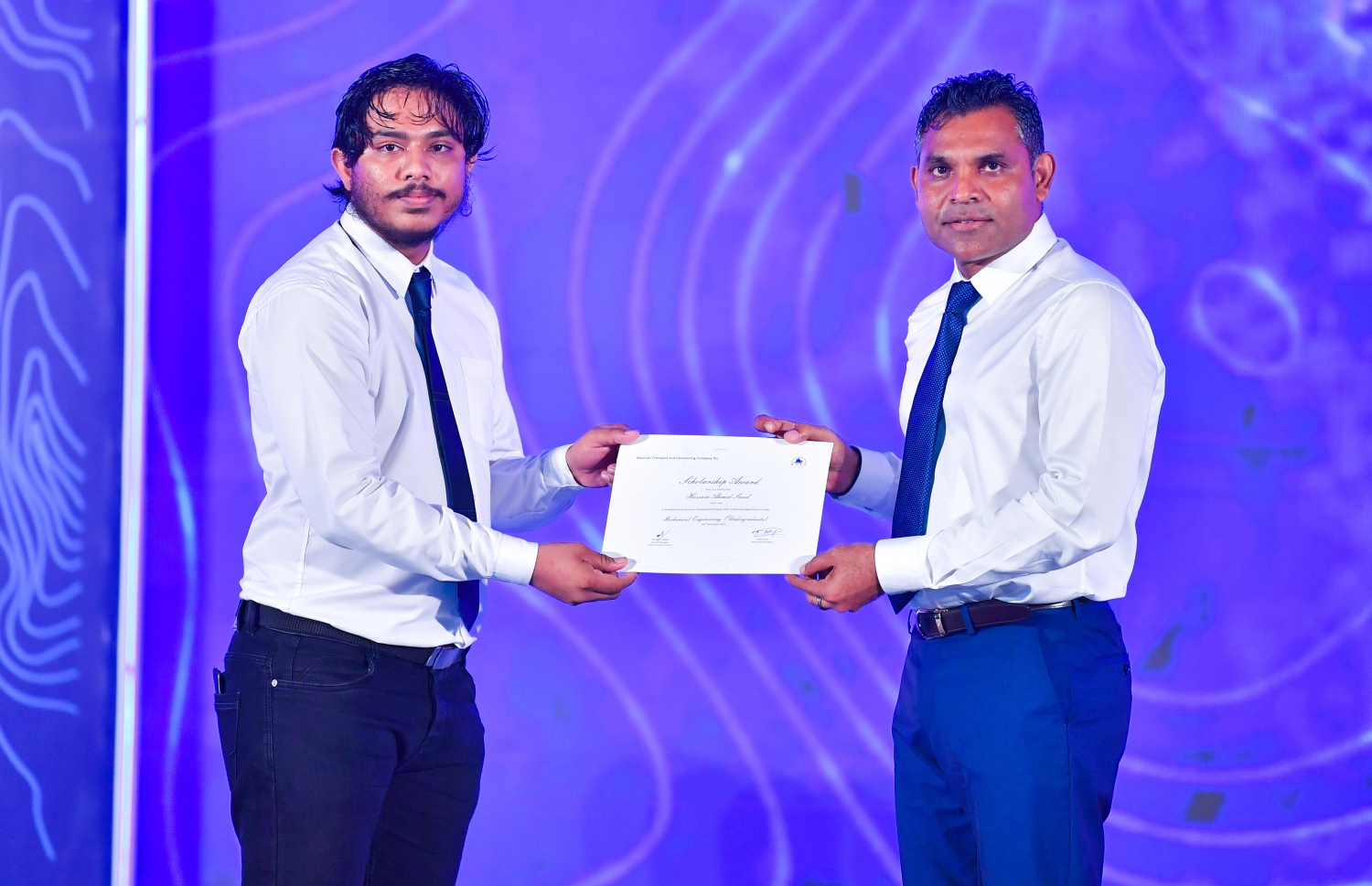 މާލެ: ޑިސެމްބަރު 19، 2021: އެމްޓީސީސީގެ 41 ވަނަ އަހަރީ ދުވަސް ފާހަގަކުރަން ބޭއްވި ޖަލްސާގައި، މި އަހަރުގެ މުވައްޒަފުން ތަމްރީންކުރުމުގެ ޕްރޮގްރާމަށް ހޮވިފައިވާ މުވައްޒަފަކަށް ނައިބު ރައީސް ފައިސަލް ނަސީމް(ކ) ލިޔުން ހަވާލު ކުރައްވަނީ.-- ފޮޓޯ: ރައީސް އޮފީސް