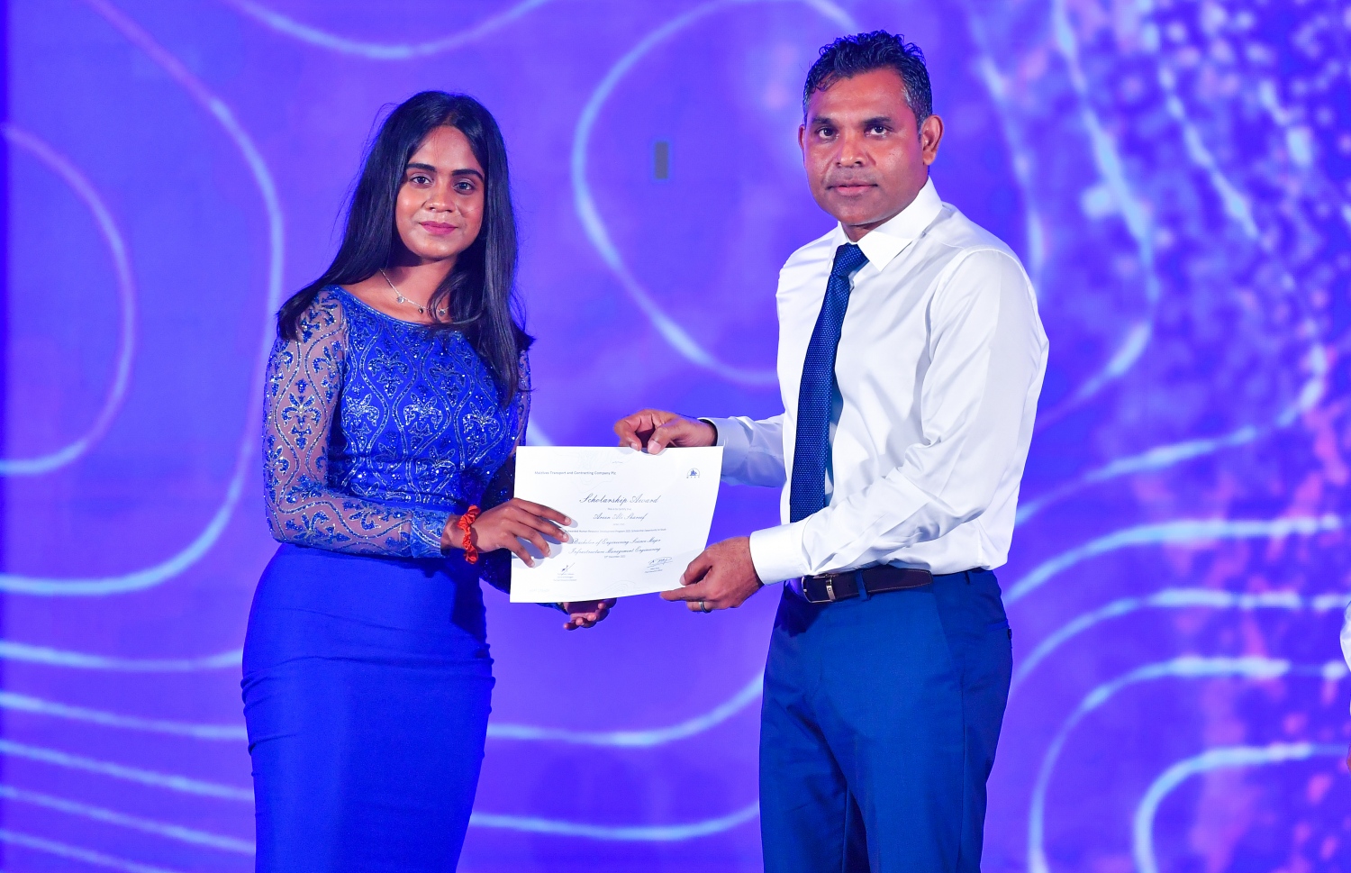 މާލެ: ޑިސެމްބަރު 19، 2021: އެމްޓީސީސީގެ 41 ވަނަ އަހަރީ ދުވަސް ފާހަގަކުރަން ބޭއްވި ޖަލްސާގައި، މި އަހަރުގެ މުވައްޒަފުން ތަމްރީންކުރުމުގެ ޕްރޮގްރާމަށް ހޮވިފައިވާ މުވައްޒަފަކަށް ނައިބު ރައީސް ފައިސަލް ނަސީމް(ކ) ލިޔުން ހަވާލު ކުރައްވަނީ.-- ފޮޓޯ: ރައީސް އޮފީސް