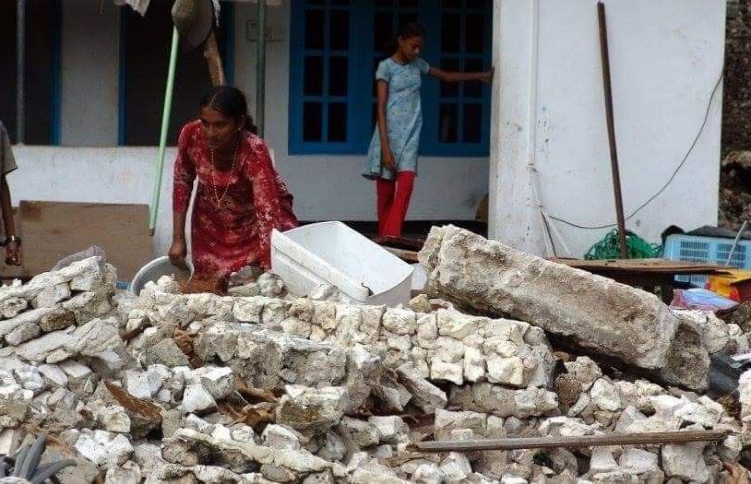 މުންޑުއަށް ރާޅު އަރައި ގެއްލުން ލިބުނު ގެއެއް ކައިރީގައި ކުޑަ ދެ ކުއްޖަކު މަޑުކޮށްލައިގެން.