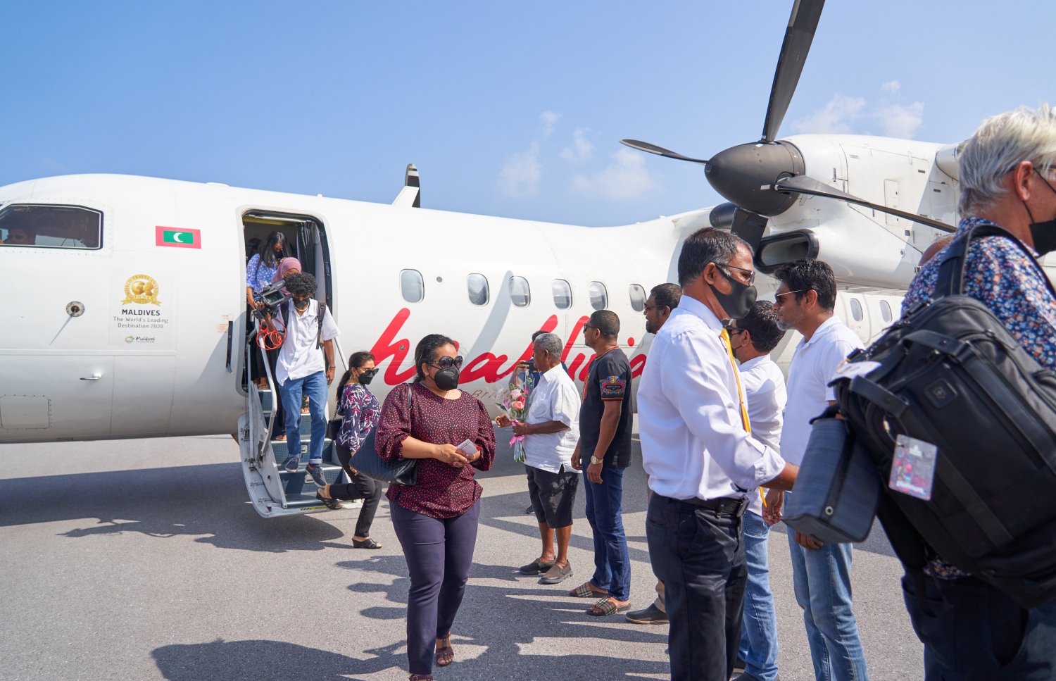 ޅ. މަޑިވަރު: ޑިސެމްބަރު 25، 2021: ޗަމްޕާ ބްރަދާސް އިން ޅ. މަޑިވަރުގައި ހެދި އެއާޕޯޓަށް ޓެސްޓް ފްލައިޓަށްފަހު، ފުރަތަމަ ފްލައިޓުގައި ބައިބެރިވި ބޭފުޅުންނަށް އެ ކުންފުނީގެ ޗެއާމަން މުހައްމަދު މޫސާ (އުއްޗު) މަރުހަބާ ދަންނަވަނީ.-- ފޮޓޯ: ކުރެއްދޫ ރިސޯޓް