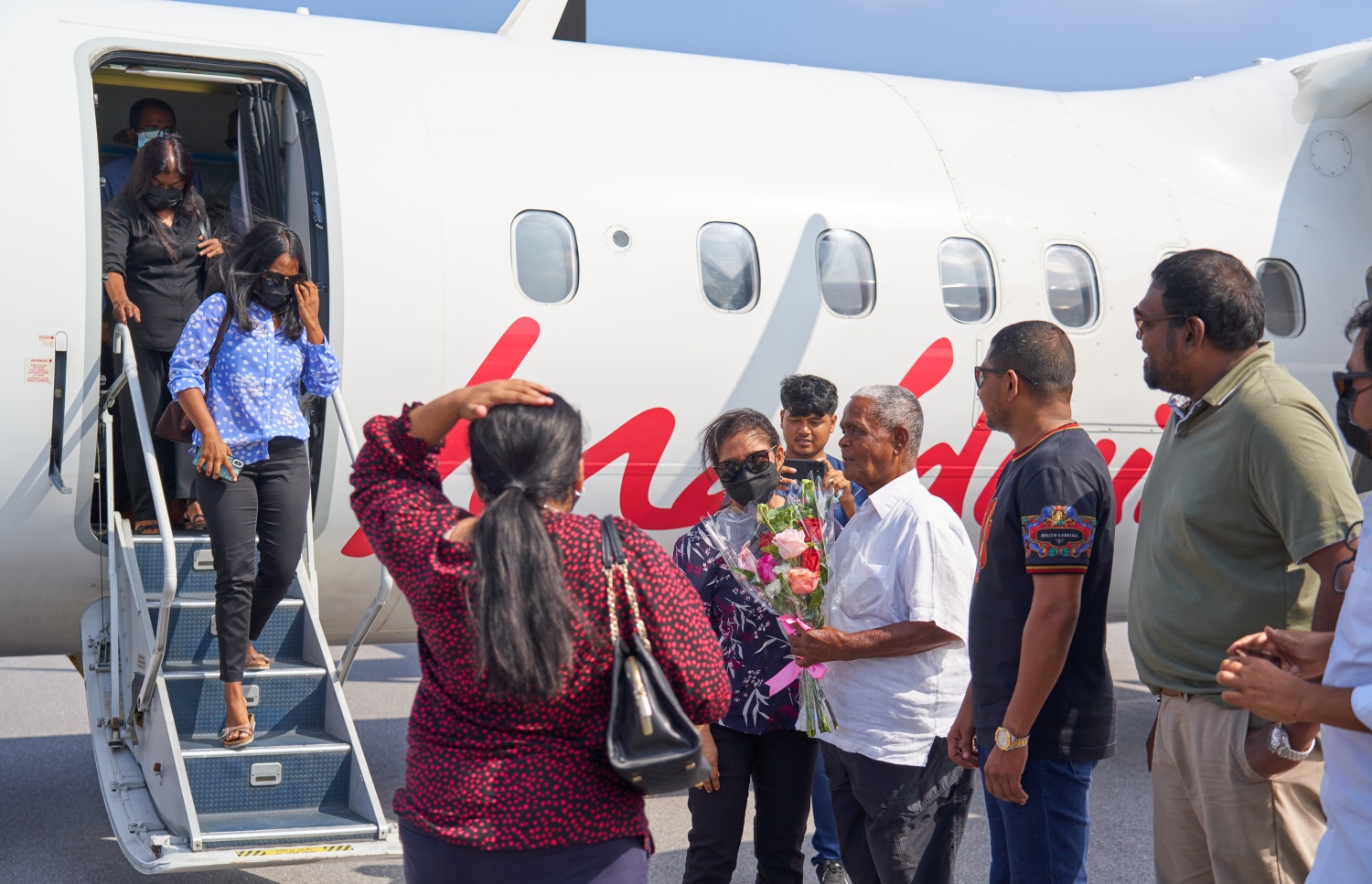 ޅ. މަޑިވަރު: ޑިސެމްބަރު 25، 2021: ޗަމްޕާ ބްރަދާސް އިން ޅ. މަޑިވަރުގައި ހެދި އެއާޕޯޓަށް ޓެސްޓް ފްލައިޓަށްފަހު، ފުރަތަމަ ފްލައިޓުގައި ބައިބެރިވި އެ ކުންފުނީގެ ޗެއާމަން މުހައްމަދު މޫސާ (އުއްޗު) އެއާޕޯޓުން މަރުހަބާ ދަންނަވަނީ.-- ފޮޓޯ: ކުރެއްދޫ ރިސޯޓް