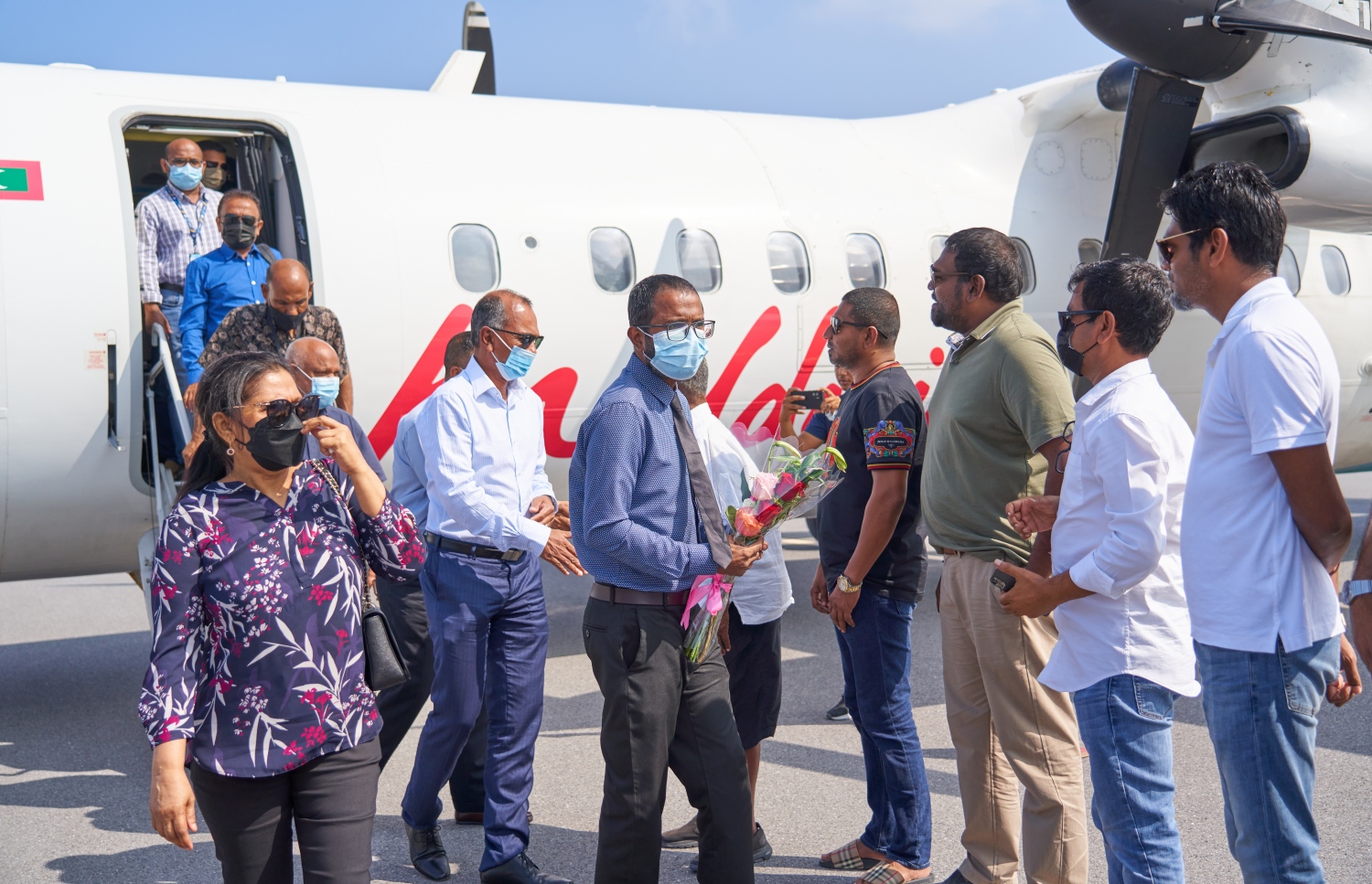 ޅ. މަޑިވަރު: ޑިސެމްބަރު 25، 2021: ޗަމްޕާ ބްރަދާސް އިން ޅ. މަޑިވަރުގައި ހެދި އެއާޕޯޓަށް ޓެސްޓް ފްލައިޓަށްފަހު، ފުރަތަމަ ފްލައިޓުގައި ބައިބެރިވި ބޭފުޅުންނަށް އެއާޕޯޓުން މަރުހަބާ ދަންނަވަނީ.-- ފޮޓޯ: ކުރެއްދޫ ރިސޯޓް