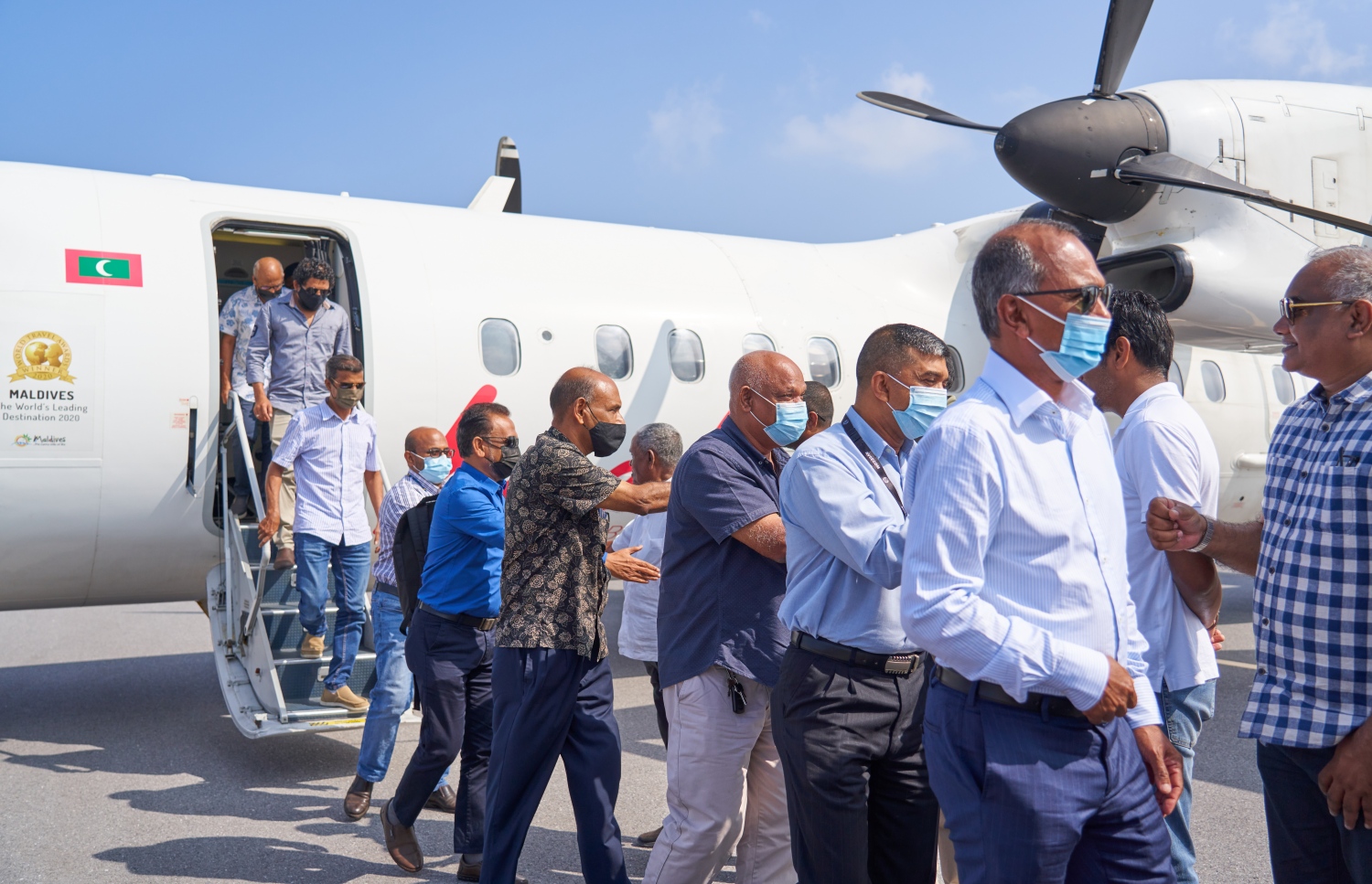 ޅ. މަޑިވަރު: ޑިސެމްބަރު 25، 2021: ޗަމްޕާ ބްރަދާސް އިން ޅ. މަޑިވަރުގައި ހެދި އެއާޕޯޓަށް ޓެސްޓް ފްލައިޓަށްފަހު، ފުރަތަމަ ފްލައިޓުގައި ބައިބެރިވި ބޭފުޅުންނަށް އެއާޕޯޓުން މަރުހަބާ ދަންނަވަނީ.-- ފޮޓޯ: ކުރެއްދޫ ރިސޯޓް