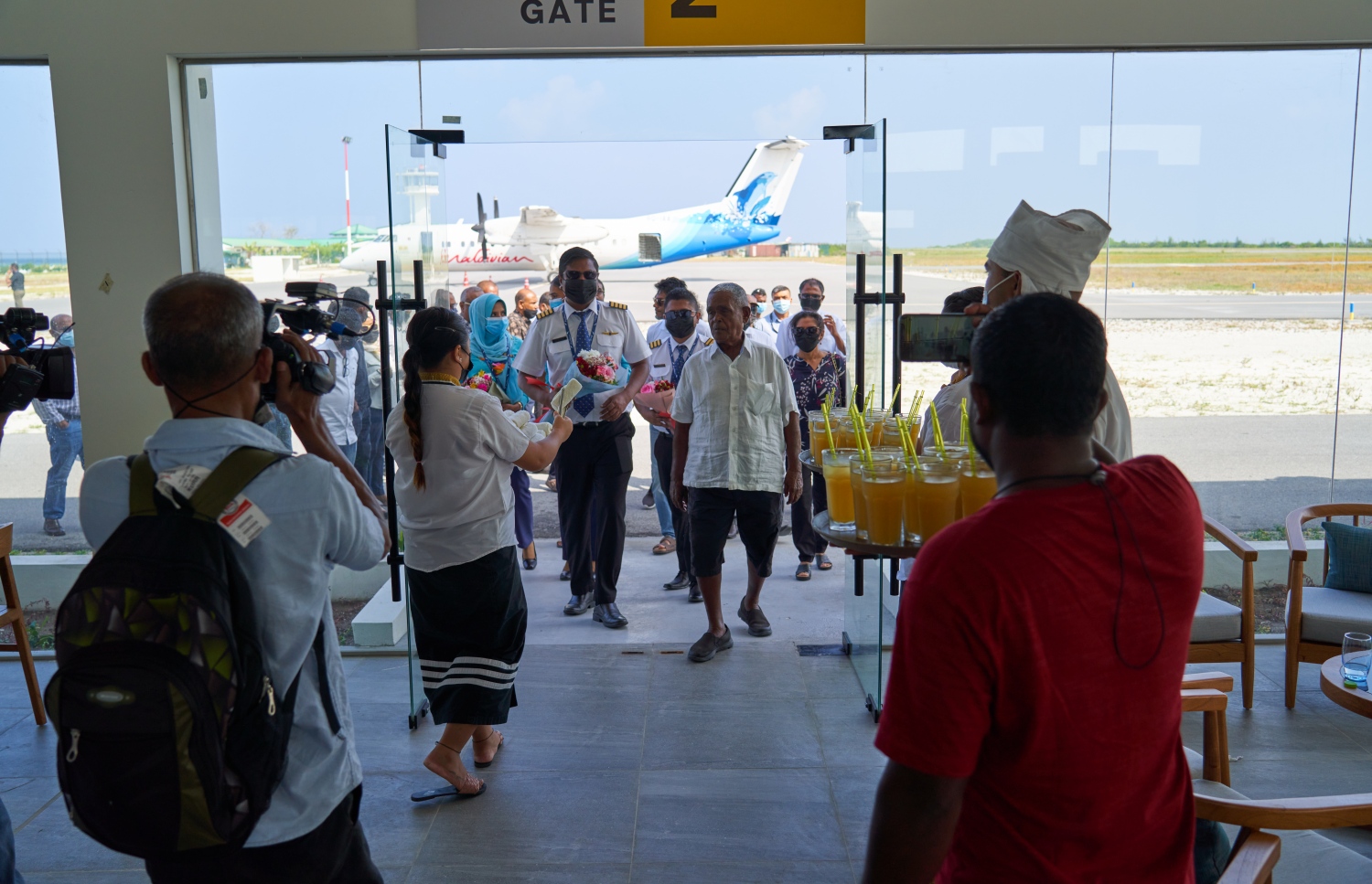 ޅ. މަޑިވަރު: ޑިސެމްބަރު 25، 2021: ޗަމްޕާ ބްރަދާސް އިން ޅ. މަޑިވަރުގައި ހެދި އެއާޕޯޓަށް ޓެސްޓް ފްލައިޓް ޖެއްސުމަށްފަހު، އެ ކުންފުނީގެ ޗެއާމަން މުހައްމަދު މޫސާ (އުއްޗު) އެއާޕޯޓަށް ވަންނަވާއިރު، އުއްޗުއަށް އެއާޕޯޓުން މަރުހަބާ ދަންނަވަނީ.-- ފޮޓޯ: ކުރެއްދޫ ރިސޯޓް