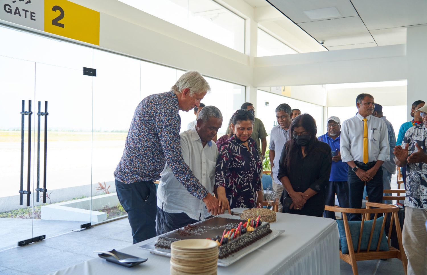 ޅ. މަޑިވަރު: ޑިސެމްބަރު 25، 2021: ޗަމްޕާ ބްރަދާސް އިން ޅ. މަޑިވަރުގައި ހެދި އެއާޕޯޓަށް ޓެސްޓް ފްލައިޓް ޖެއްސުމަށްފަހު، އެ ކުންފުނީގެ ޗެއާމަން މުހައްމަދު މޫސާ (އުއްޗު) އުފަންދުވަހުގެ ކޭކު ފަޅަނީ.-- ފޮޓޯ: ކުރެއްދޫ ރިސޯޓް