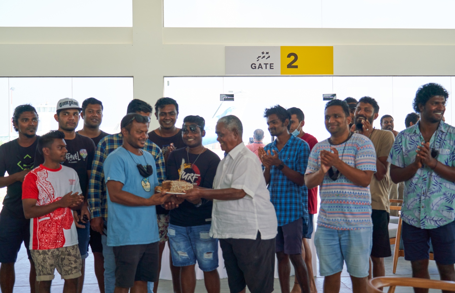 ޅ. މަޑިވަރު: ޑިސެމްބަރު 25، 2021: ޗަމްޕާ ބްރަދާސް އިން ޅ. މަޑިވަރުގައި ހެދި އެއާޕޯޓަށް ޓެސްޓް ފްލައިޓް ޖެއްސުމަށްފަހު، އެ ކުންފުނީގެ ޗެއާމަން މުހައްމަދު މޫސާ (އުއްޗު) އަށް އެއާޕޯޓުގެ މުވައްޒަފުންގެ ފަރާތުން ކޭކެއް ދެނީ.-- ފޮޓޯ: ކުރެއްދޫ ރިސޯޓް