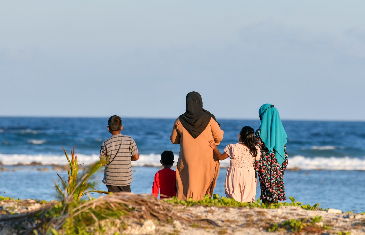 ކުޑަކުދިންތަކަކާއެކު، މީހަކު ހުޅުމާލޭ ބީޗްގައި މަޑުކޮށްލައިގެން.-- ފޮޓޯ: ފަޔާޒު މޫސާ/ މިހާރު