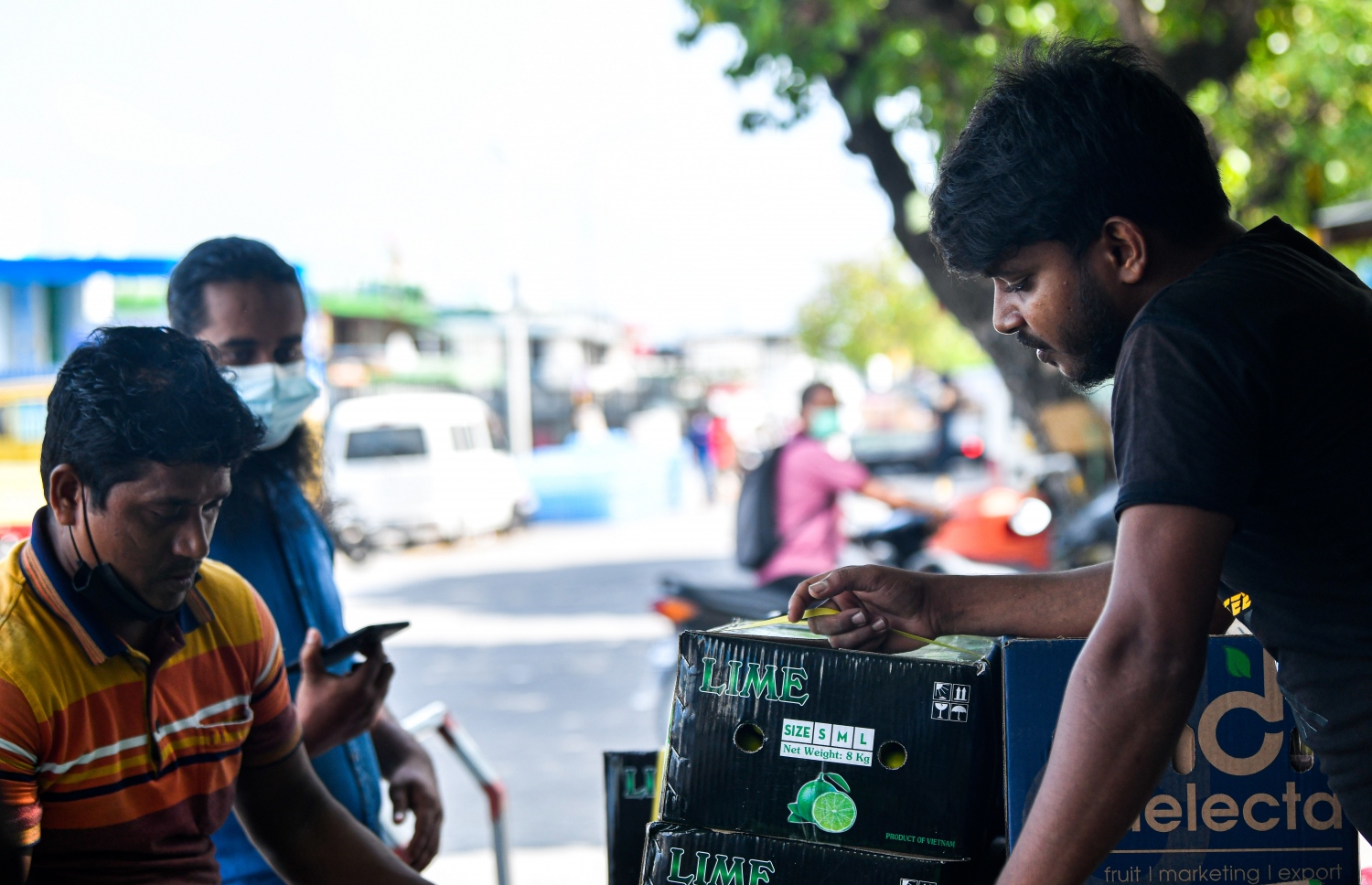 މާރުކޭޓު ސަރަހައްދުގައި މަސައްކަތްކުރާ ދެ ބިދޭސީއަކު މާސްކް ނާޅާ މަސައްކަތުގައި، މި ސަރަހައްދަކީ ގިނަބަޔަކު ވިޔަފާރިކުރަން ޖަމާވާ ސަރަހައްދެއް-- ފޮޓޯ/ ފަޔާޒު މޫސާ