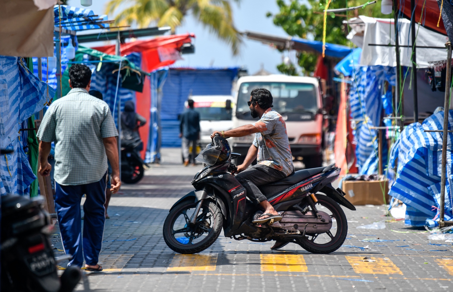 މާލޭ ސަރަހައްދުގައި ކޮވިޑް ކޭސްތައް އިތުރުވާތީ މިހާރު ބަންދުކޮށްފައިވާ، ރަސްފަންނު ސަރަހައްދުގެ ނައިޓް މާކެޓް ސަރަހައްދުގައި މީހަކު މާސްކް ނާޅާ. -- ފޮޓޯ: ފަޔާޒު މޫސާ / މިހާރު