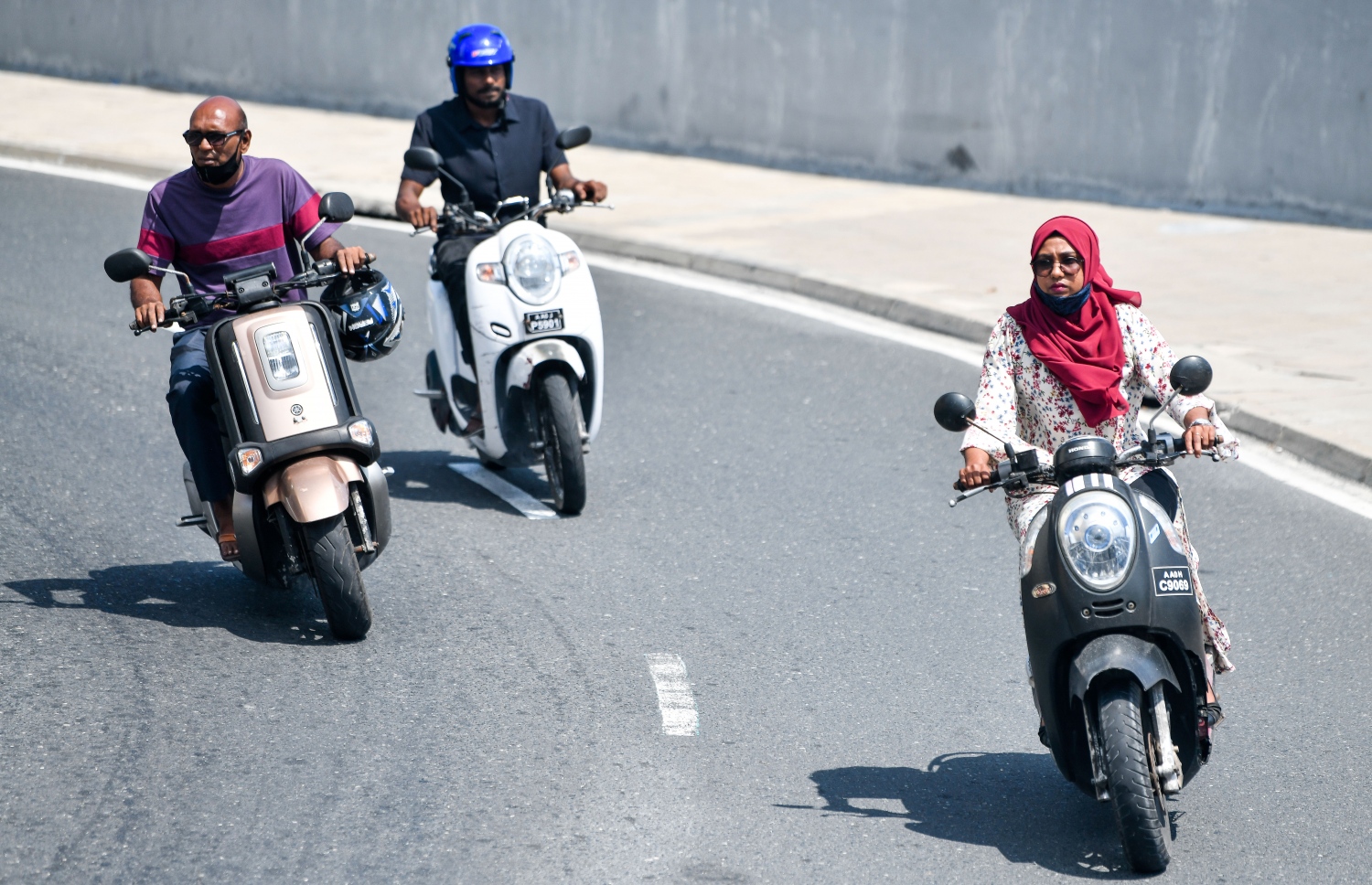 ބޮޑުތަކުރުފާނު މަގުން ސައިކަލްގައި ތިން މީހަކު ދުއްވާފައި އަންނަނީ. މާސްކް ނާޅައި މަގުމަތީ އުޅޭ މީހުން ވަރަށް ގިނަ. -- ފޮޓޯ: ފަޔާޒު މޫސާ/މިހާރު