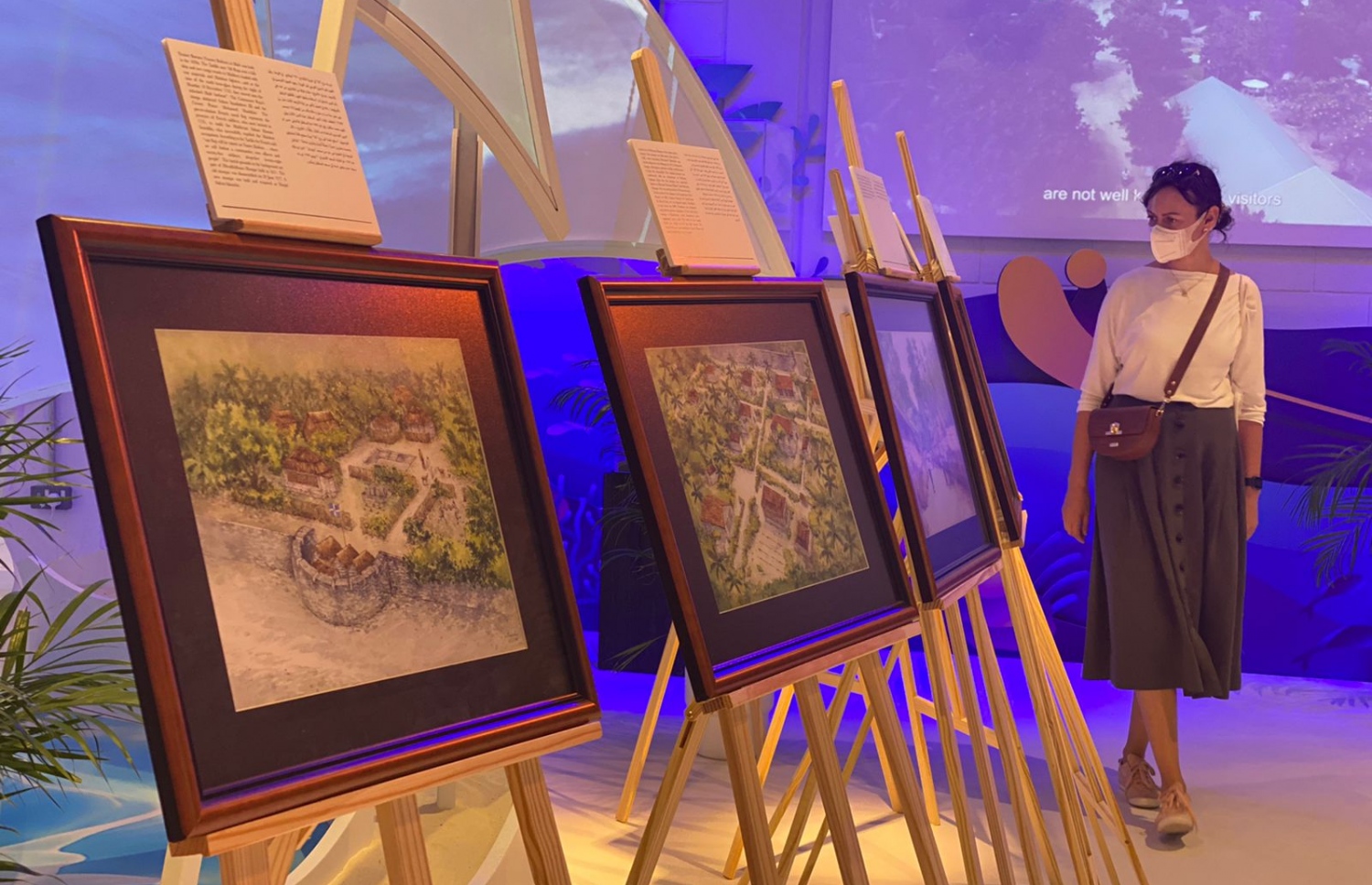 ދުބާއީ އެކްސްޕޯ 2020 ގައި ބޭއްވި އައިމިނަތު ޝިމްހާ ޝަކީބްގެ "މާލޭގެ ކިއްލާ" އާޓް އެގްޒިބިޝަނަށް ދިޔަ މީހަކު އާޓްވޯކްތައް ބަލައިލަނީ.-- ފޮޓޯ: ޝިމްހާ