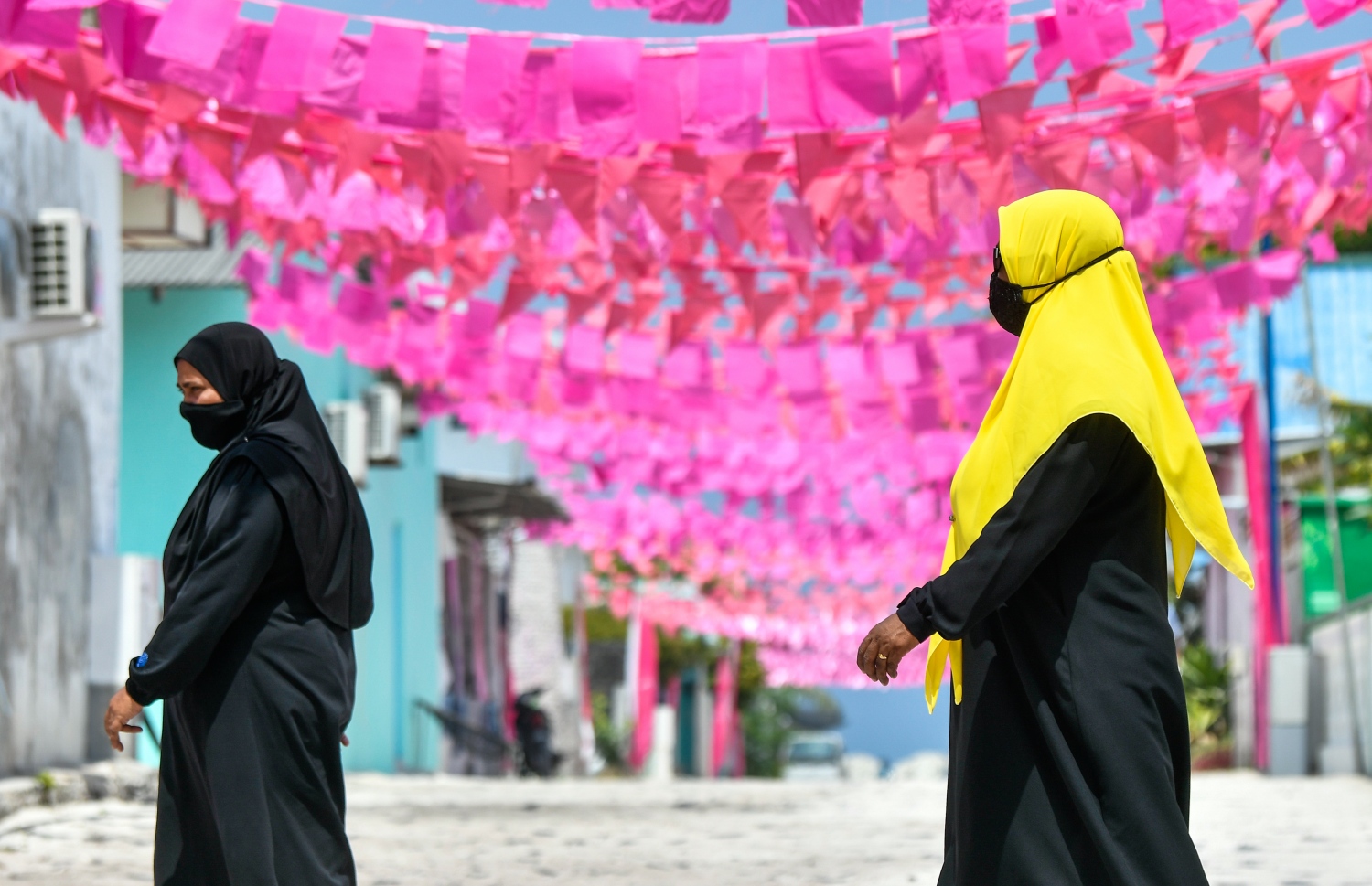 ކޮމަންޑޫގެ މަގެއްގައި ދެ އަންހެނަކު ހިނގާފައި ދަނީ: މި ރަށުގައި ކެމްޕޭން ފޯރިގަދަ. -- ފޮޓޯ: ފަޔާޒް މޫސާ/ މިހާރު