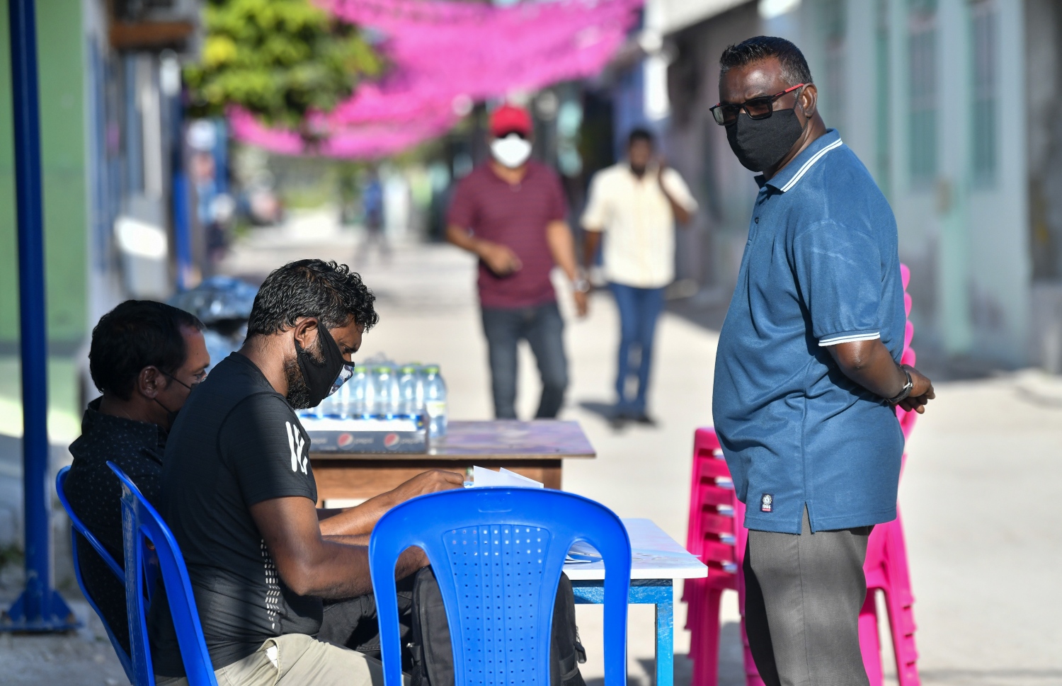 ކޮމަންޑޫ ޕްރީ ސްކޫލްގައި ހުންނަ ވޯޓުލާ މަރުކަޒު ބޭރުގައި ޕީޕީއެމްގެ އޮބްޒާވަރުން މޭޒުޖަހައިގެން ހަރަކާތްތެރިވަނީ-- ފޮޓޯ: ފަޔާޒު މޫސާ/ މިހާރު