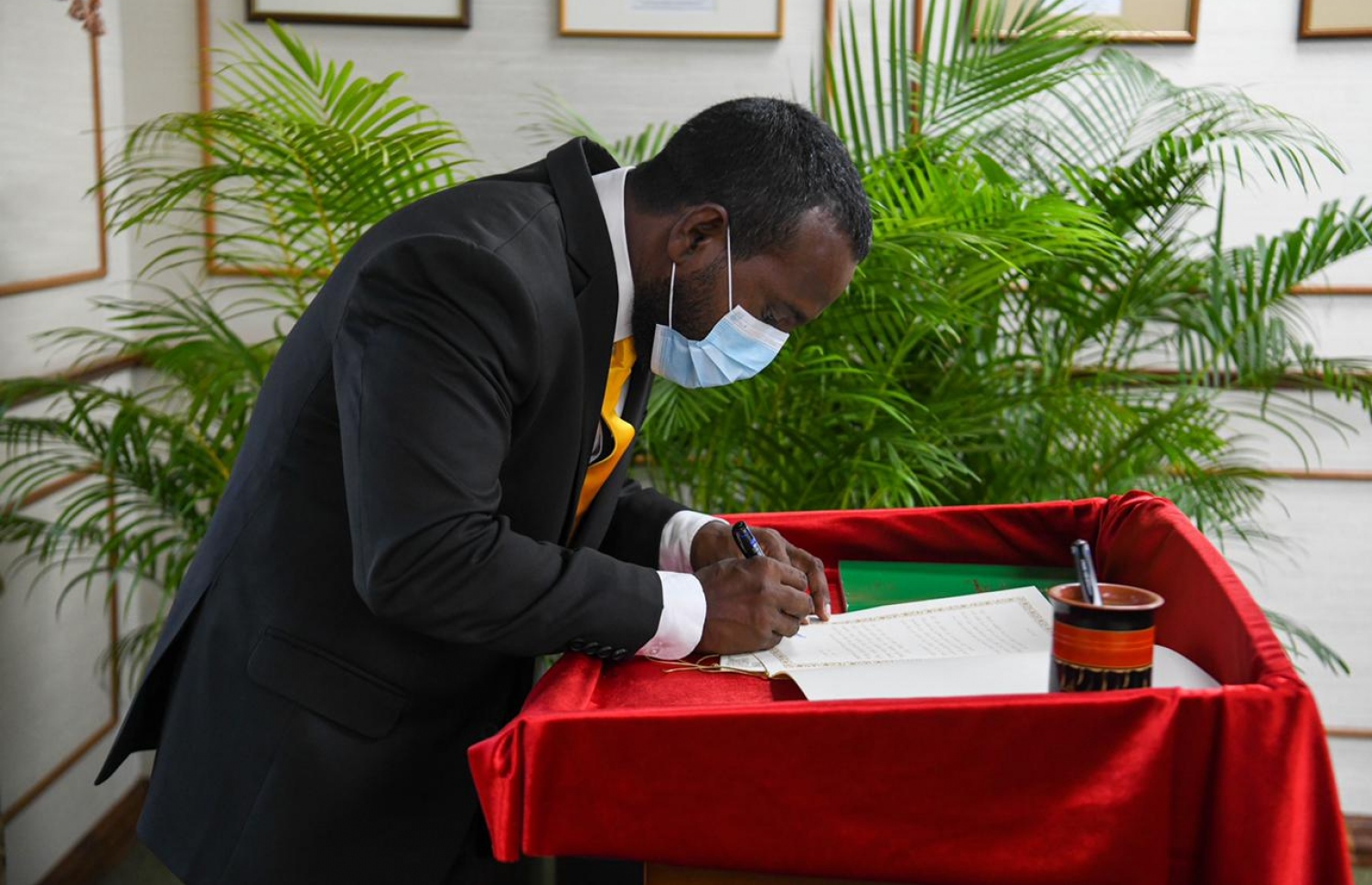 މަގާމުގެ ހުވާކުރެއްވުމަށް ފަހު، ހުވާގެ ލިޔުމުގައި ރާޝިދު މިއަދު ސޮއިކުރައްވަނީ.---ފޮޓޯ: މަޖިލިހުގެ އިދާރާ