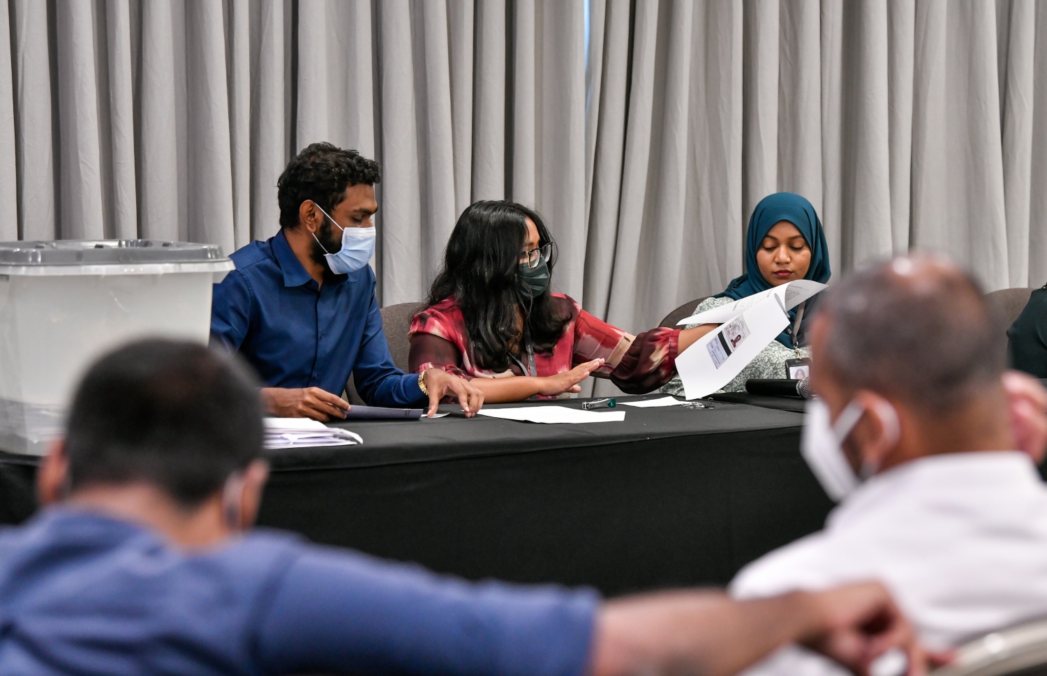 ހުޅުމާލޭގެ ދެވަނަ ފިޔަވަހީގެ ބީޗް ފްރަންޓުން ވިއްކާ ބިންތަކަށް ހުށަހެޅި ބީލަންތައް ކަނޑައި، ބީލަމުގެ އަގުތައް އެޗްޑީސީގެ އޮފިޝަލަކު އިއުލާން ކުރާއިރު އެހެން މުވައްޒަފުން އެހީތެރިވަނީ.---ފޮޓޯ: ފަޔާޒު މޫސާ/ މިހާރު