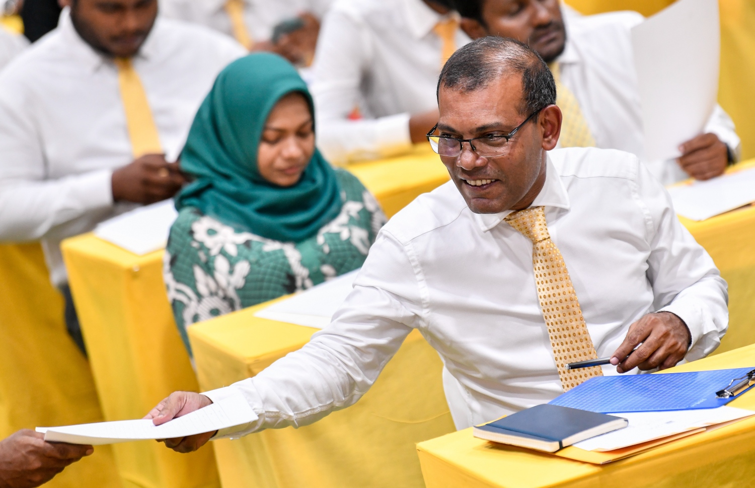 އިސްކަންދަރު ސްކޫލުގައި ބޭއްވި އެމްޑީޕީގެ ގައުމީ މަޖިލީހުގެ ހަތަރު ވަނަ ދައުރުގެ ދެ ވަނަ ޖަލްސާގައި އެ ޕާޓީގެ ރައީސް މުހައްމަދު ނަޝީދު، ޕީޖީ ލީޑަރު އަލީ އާޒިމާ ކަރުދާސްތަކެއް ހަވާލުކުރައްވަނީ.---ފޮޓޯ: ފަޔާޒު މޫސާ / މިހާރު