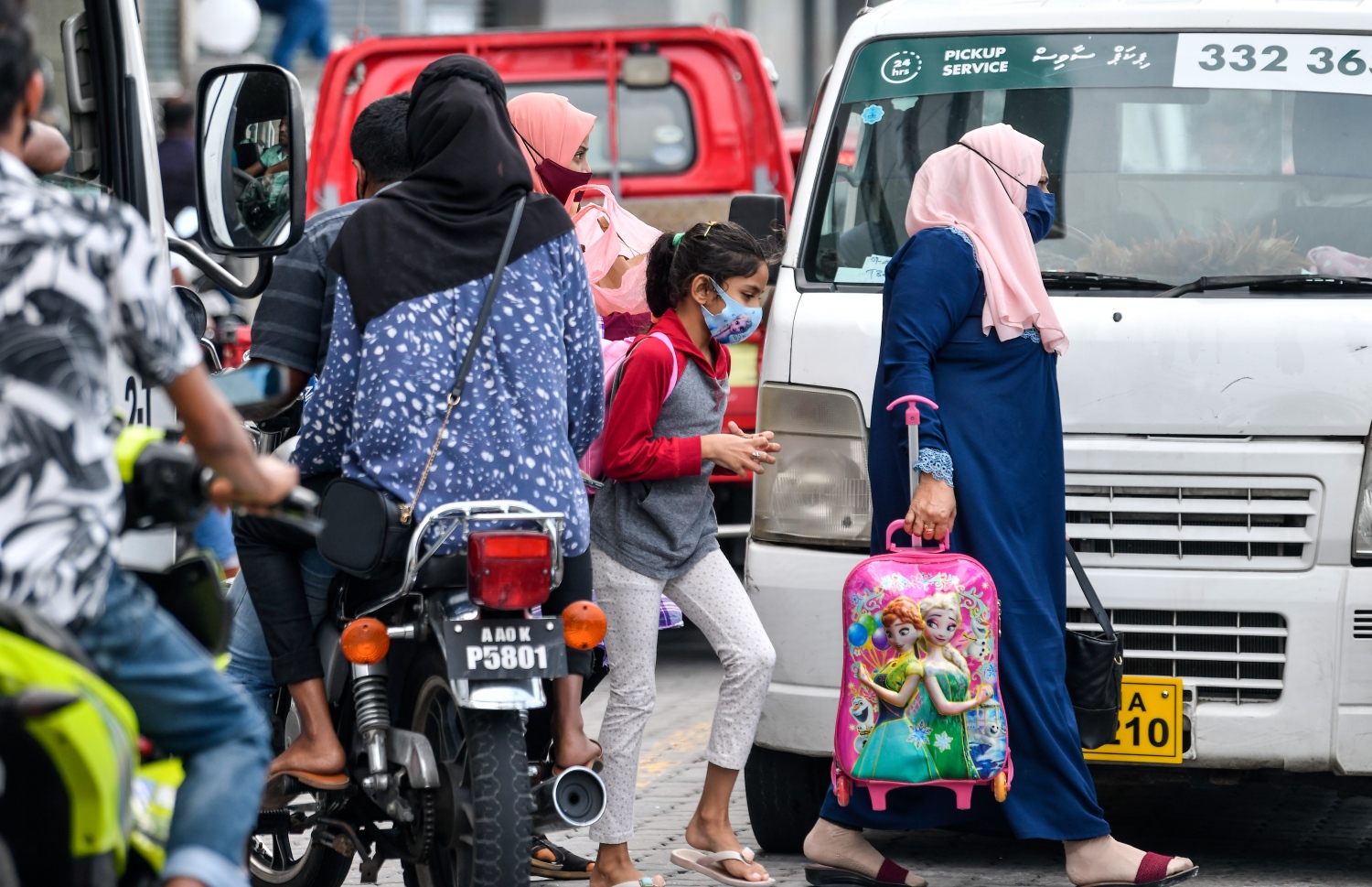 ފޮރިން މިނިސްޓްރީ ކުރިމައްޗަށް ގާތްކޮށްފައި އޮތް ލޯންޗު ފެރީއަކުން ފުރަން ދިޔަ ބަޔަކު، ތޮއްޖެހިފައި އޮތް ޓްރެފިކް ތެރެއިން ލޯންޗަށް އަރަން ދަނީ.-- ފޮޓޯ: ފަޔާޒް މޫސާ / މިހާރު