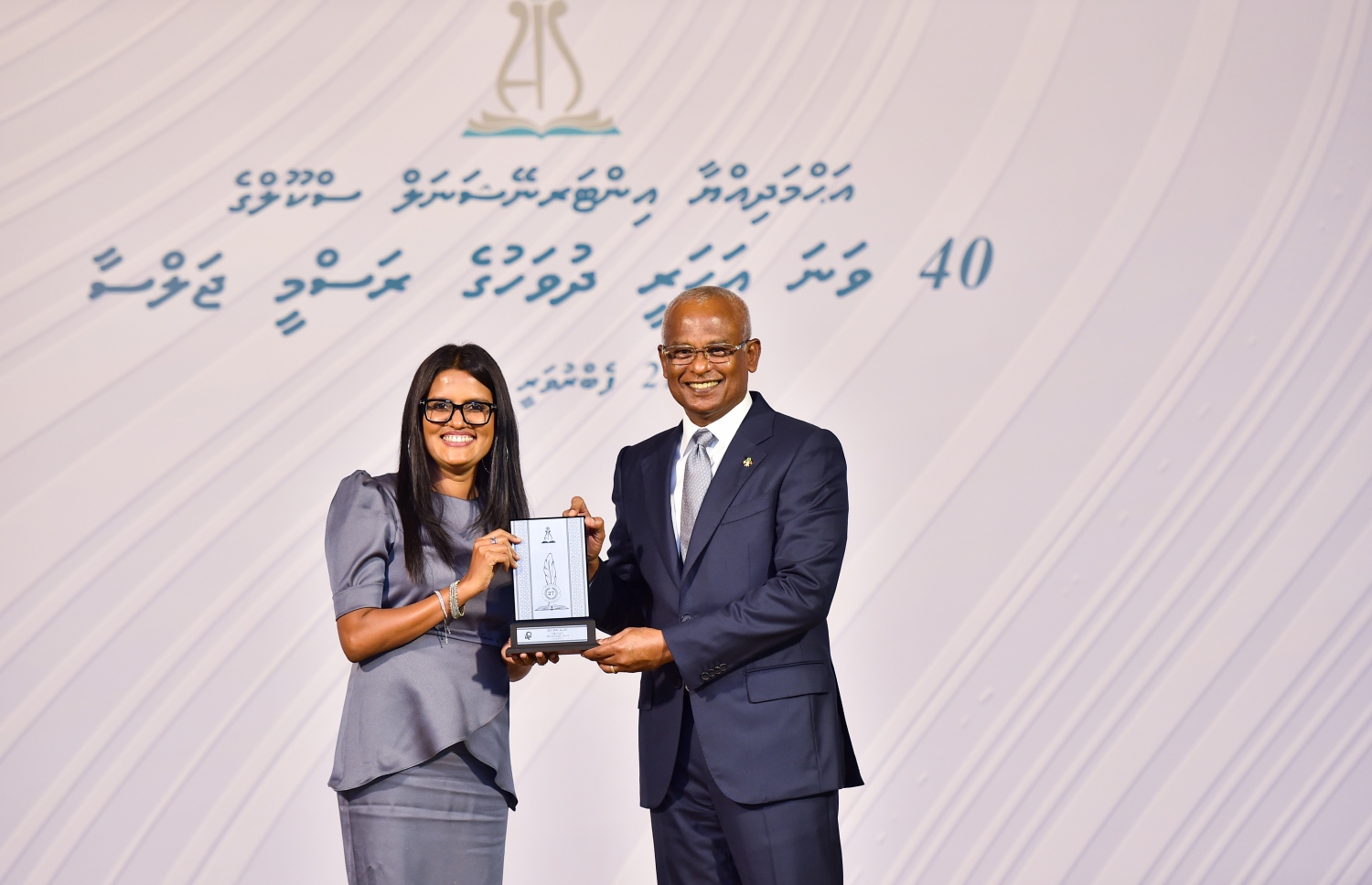 އަހުމަދިއްޔާ ސްކޫލަށް 40 އަހަރު ފުރުމުގެ މުނާސަބަތުގައި ބޭއްވި ކުލަގަދަ ރަސްމިއްޔާތުގައި ރައީސް އިބްރާހިމް މުހައްމަދު ސޯލިހު، އެ ސްކޫލަށް 25 އަހަރަށް ވުރެ ދިގު މުއްދަތެއްގައި ހިދުމަތް ކޮށްދިން މީހަކަށް ހަނދާނީ ފިލައެއް ދެނީ.-- ފޮޓޯ: ރައީސް އޮފީސް