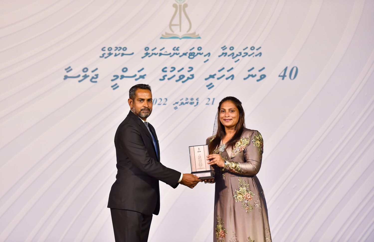 އަހުމަދިއްޔާ ސްކޫލަށް 40 އަހަރު ފުރުމުގެ މުނާސަބަތުގައި ބޭއްވި ކުލަގަދަ ރަސްމިއްޔާތުގައި އެޑިއުކޭޝަން މިނިސްޓަރު އައިޝަތު އަލީ އެ ސްކޫލުގެ ޓީޗަރަކަށް ހަނދާނީ ފިލައެއް ދެނީ.-- ފޮޓޯ: ރައީސް އޮފީސް