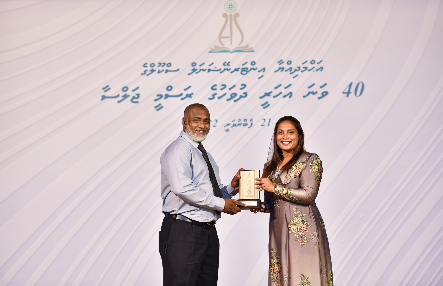 އަހުމަދިއްޔާ ސްކޫލަށް 40 އަހަރު ފުރުމުގެ މުނާސަބަތުގައި ބޭއްވި ކުލަގަދަ ރަސްމިއްޔާތުގައި އެޑިއުކޭޝަން މިނިސްޓަރު އައިޝަތު އަލީ އެ ސްކޫލުގެ ޓީޗަރަކަށް ހަނދާނީ ފިލައެއް ދެނީ.-- ފޮޓޯ: ރައީސް އޮފީސް