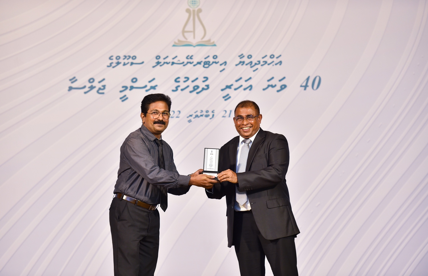 އަހުމަދިއްޔާ ސްކޫލަށް 40 އަހަރު ފުރުމުގެ މުނާސަބަތުގައި ބޭއްވި ކުލަގަދަ ރަސްމިއްޔާތުގައި ޓޫރިޒަމް މިނިސްޓަރު އަބްދުﷲ މައުސޫމް އެ ސްކޫލުގެ ޓީޗަރަކަށް ހަނދާނީ ފިލައެއް ދެނީ.-- ފޮޓޯ: ރައީސް އޮފީސް