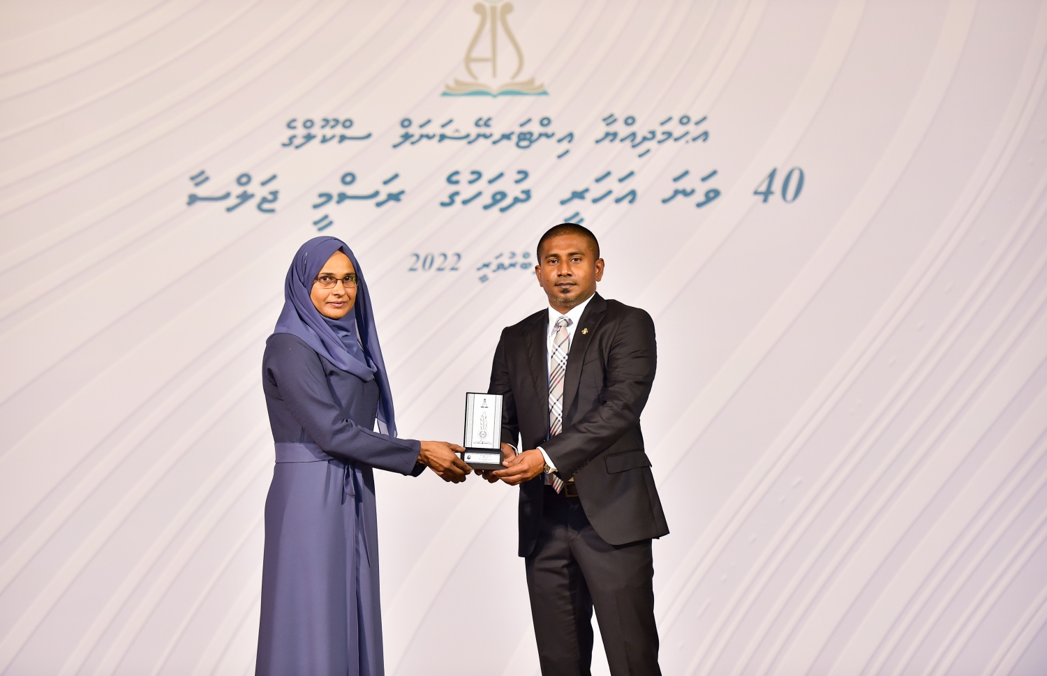އަހުމަދިއްޔާ ސްކޫލަށް 40 އަހަރު ފުރުމުގެ މުނާސަބަތުގައި ބޭއްވި ކުލަގަދަ ރަސްމިއްޔާތުގައި ޔޫތު މިނިސްޓަރު އަހުމަދު މަހުލޫފް އެ ސްކޫލުގެ ޓީޗަރަކަށް ހަނދާނީ ފިލައެއް ދެނީ.-- ފޮޓޯ: ރައީސް އޮފީސް