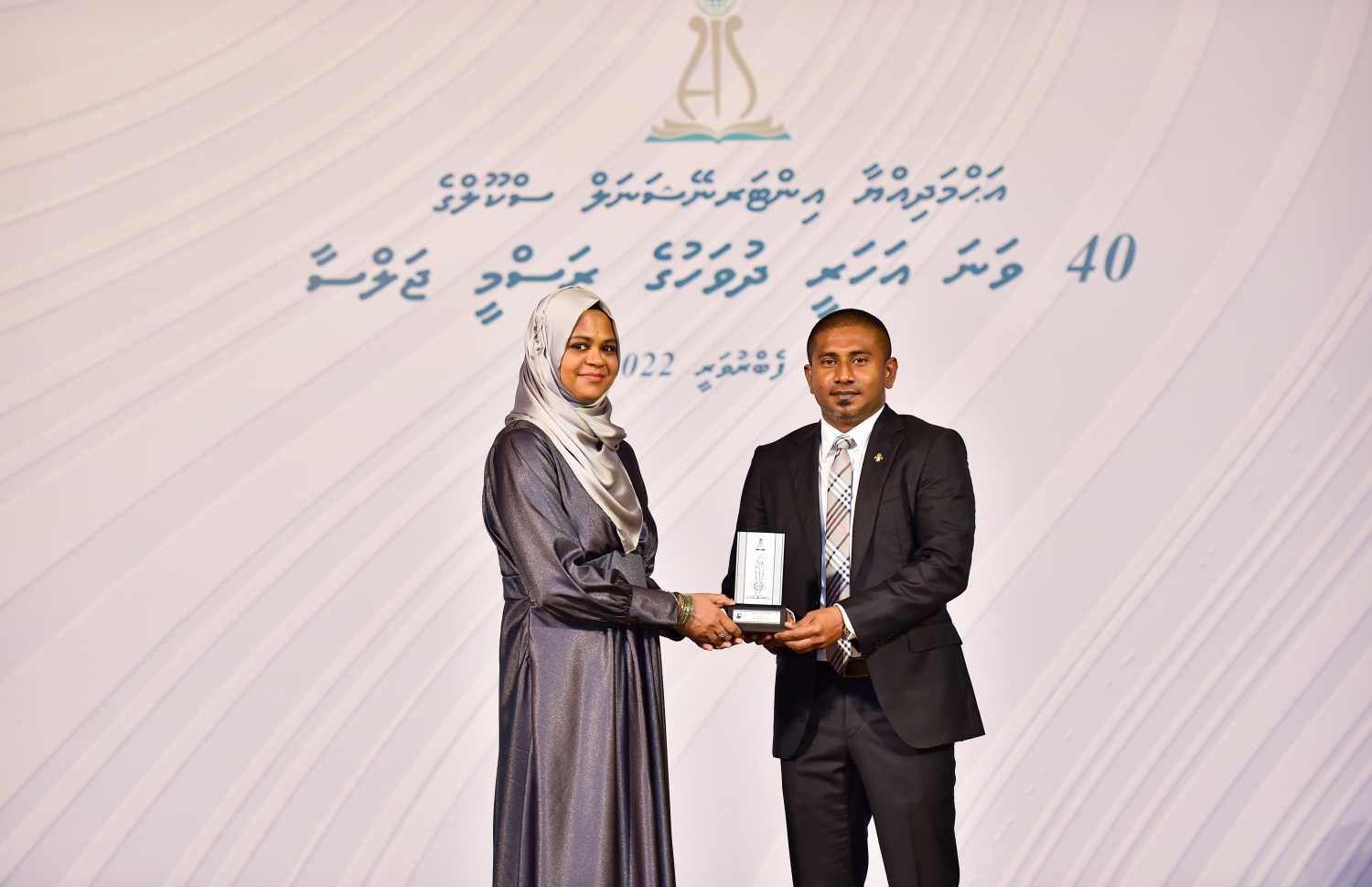 އަހުމަދިއްޔާ ސްކޫލަށް 40 އަހަރު ފުރުމުގެ މުނާސަބަތުގައި ބޭއްވި ކުލަގަދަ ރަސްމިއްޔާތުގައި ޔޫތު މިނިސްޓަރު އަހުމަދު މަހުލޫފް އެ ސްކޫލުގެ ޓީޗަރަކަށް ހަނދާނީ ފިލައެއް ދެނީ.-- ފޮޓޯ: ރައީސް އޮފީސް