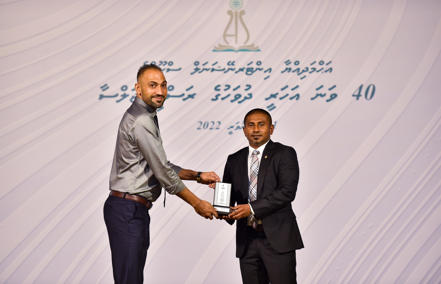 އަހުމަދިއްޔާ ސްކޫލަށް 40 އަހަރު ފުރުމުގެ މުނާސަބަތުގައި ބޭއްވި ކުލަގަދަ ރަސްމިއްޔާތުގައި ޔޫތު މިނިސްޓަރު އަހުމަދު މަހުލޫފް އެ ސްކޫލުގެ ޓީޗަރަކަށް ހަނދާނީ ފިލައެއް ދެނީ.-- ފޮޓޯ: ރައީސް އޮފީސް