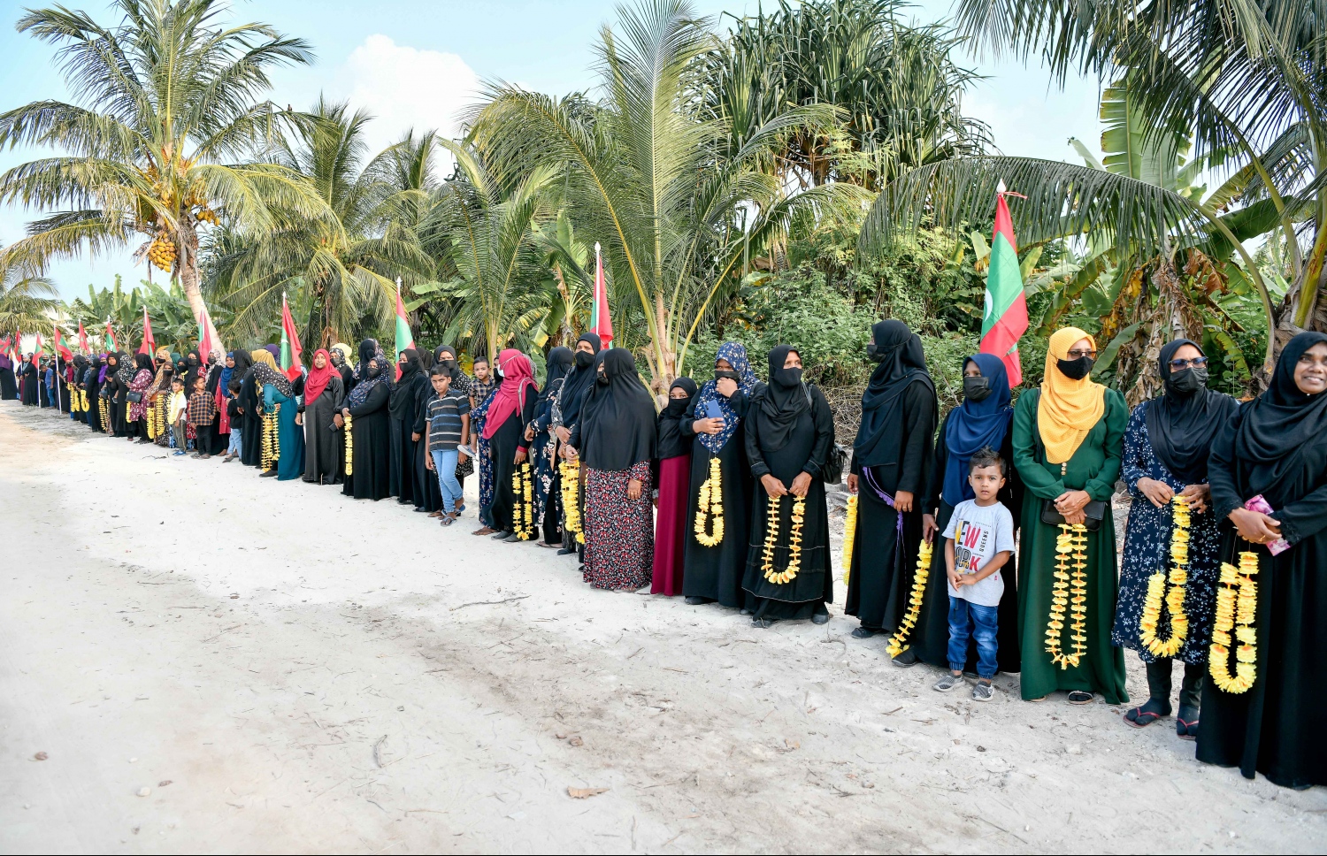 ފައްޔާޒަށް މަރުހަބާ ކިޔަން އެމްޑީޕީގެ މެމްބަރުން މިލަންދޫގެ ބޮޑުމަގުގެ ދެ ފަރާތުގައި ސަފު ހަދާލައިގެން.---ފޮޓޯ: ނިޝާން އަލީ/ މިހާރު