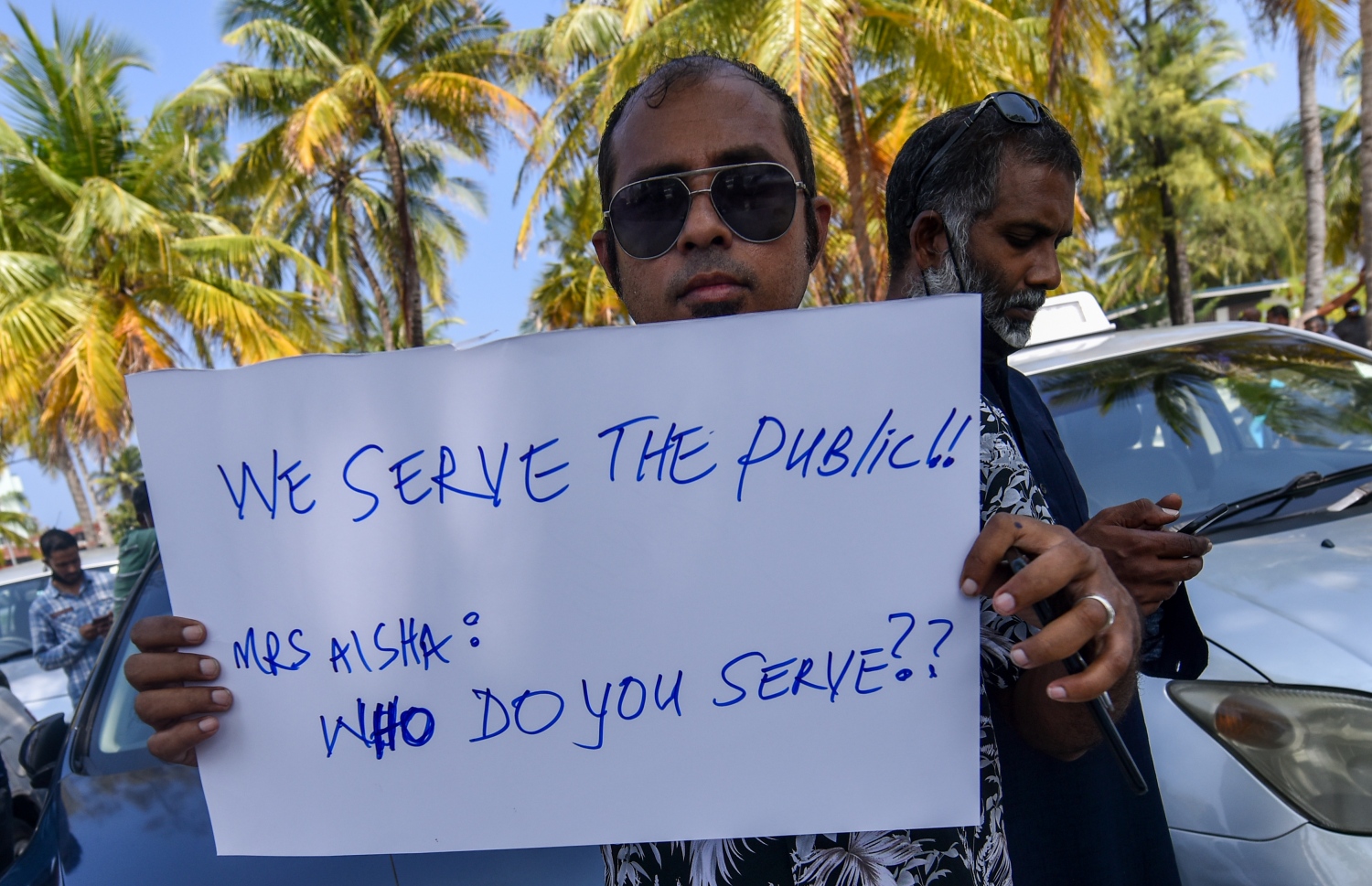 ޓްރާންސްޕޯޓް މިނިސްޓަރު އާއިޝަތު ނަހުލާއާ މެދު ހިތްހަމަނުޖެހިގެން، އޭނާ އަށް އަމާޒުކޮށް ލިޔެފައިވާ ޕޯސްޓަރެއް ހިފައިގެން ޑްރައިވަރަކު ހުޅުމާލޭ ރުއްގަނޑު ދޭއް ސަރަހައްދުގައި އިހުތިޖާޖު ކުރަނީ: ނަހުލާގެ އަރިހަށް ޑްރައިވަރުން ދިއުމުން ވެސް ހައްލެއް ހޯދައި ނުދެވުނު ކަމަށް އެ މީހުން ބުނޭ.---ފޮޓޯ: ފަޔާޒު މޫސާ/ މިހާރު