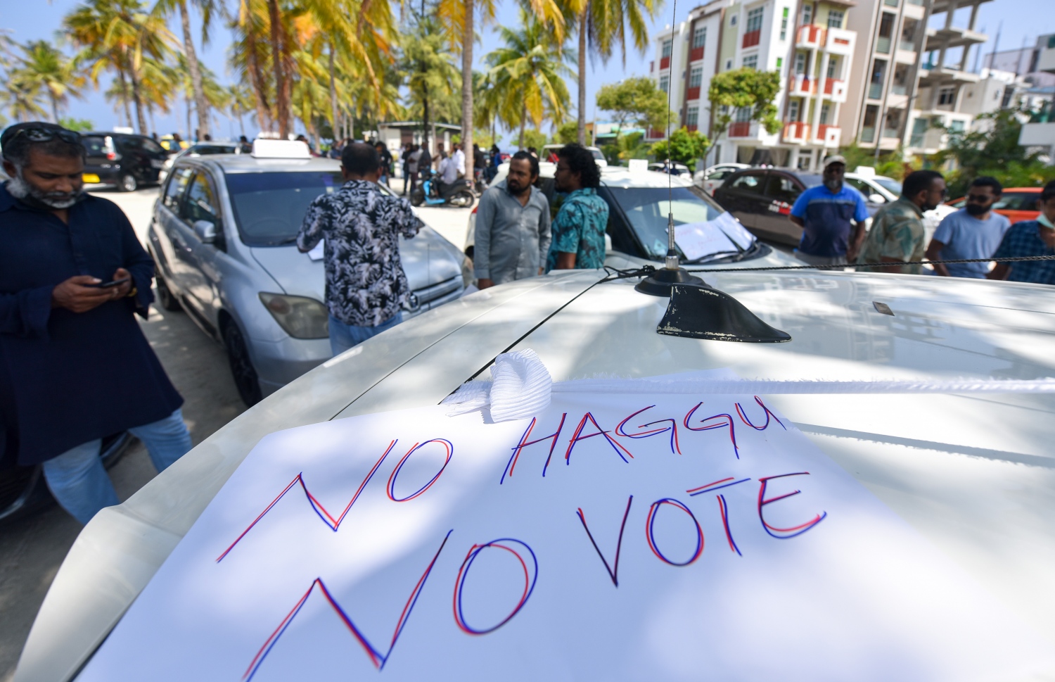 ޓެކްސީ ޑްރައިވަރުން ދަތުރުތައް ހުއްޓާލުމަށް ފަހު، ހުޅުމާލޭގެ ރުއްގަނޑު ދޭއް ސަރަހައްދުގައި އިހުތިޖާޖު ކުރާއިރު، ހައްގު ހޯދައި ނުދެވޭ ނަމަ ވޯޓު ނުދޭނެ ކަމަށް ބުނެ ލިޔެފައިވާ ޕޯސްޓަރެއް ޓެކްސީއެއްގައި ހަރުކޮށްފައި.--- ފޮޓޯ: ފަޔާޒު މޫސާ