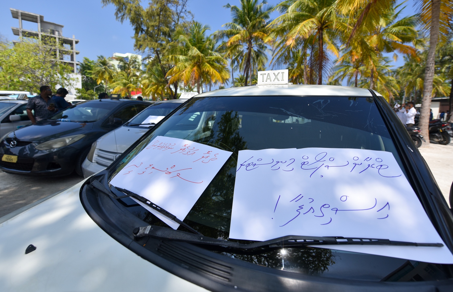 ޓެކްސީ ޑްރައިވަރުންގެ އިހުތިޖާޖު ހުޅުމާލޭ ރުއްގަނޑު ދޭއް ސަރަހައްދުގައި ކުރިއަށް ގެންދާއިރު، ޓްރާންސްޕޯޓް މިނިސްޓަރު އާއިޝަތު ނަހުލާގެ އިސްތިއުފާ އަށް ގޮވައި ލިޔެފައިވާ ޕޯސްޓަރެއް ޓެކްސީއެއްގައި ހަރުކޮށްފައި.---ފޮޓޯ: ފަޔާޒު މޫސާ/މިހާރު