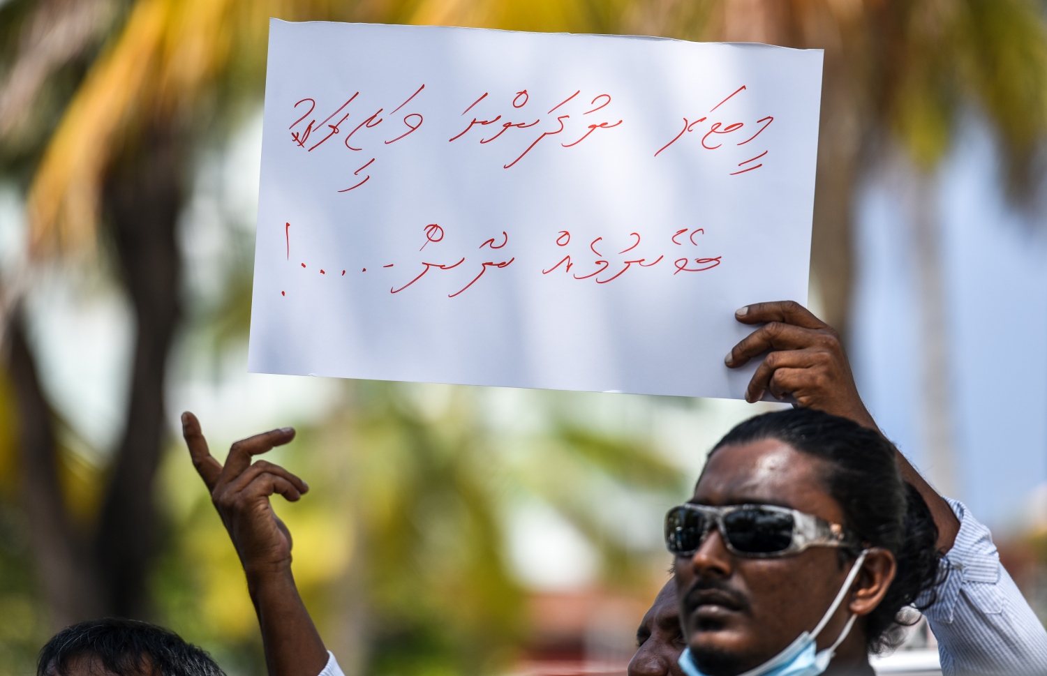 ޓްރާންސްޕޯޓް މިނިސްޓަރު އާއިޝަތު ނަހުލާ އަށް ނިސްބަތްކޮށް، "މީޓަރު ނުދަންނަ ވަޒީރަކު ބޭނުމެއް ނޫން" ކަމަށް ބުނެ ލިޔެފައިވާ ޕޯސްޓަރެއް ހިފައިގެން ޑްރައިވަރަކު އިހުތިޖާޖު ކުރަނީ: ޓެކްސީތަކުގައި މީޓަރު ހަރުކުރުމަކީ ވެސް އެ މީހުންގެ ޑިމާންޑެއް.---ފޮޓޯ: ފަޔާޒު މޫސާ/ މިހާރު