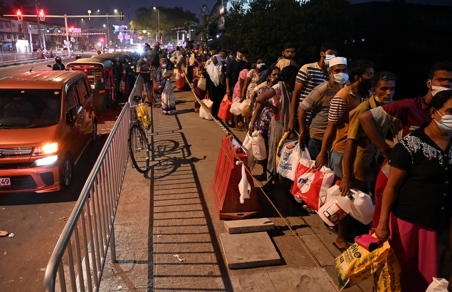 ކޮލަމްބޯ - މާޗް 20 - ސްރީ ލަންކާގެ ވެރިރަށް ކޮލަމްބޯގެ ޕެޓްރޯލް ސްޓޭޝަނެއްގެ ކައިރީ ތެޔޮ ގަންނަން މީހުން ކިޔޫ ހަދާފައި: ލަންކާގައި ކައްކާ ގޭސް ނުލިބޭތީ ގިނަ މީހުން ކައްކަން މިހާރު ބޭނުން ކުރަނީ ކަރާސީނު ތެޔޮ. --ފޮޓޯ:އޭއެފްޕީ