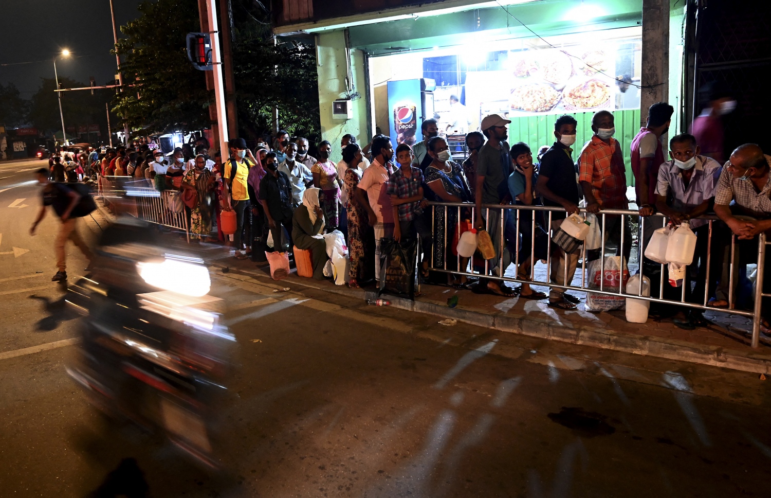 ކޮލަމްބޯ - މާޗް 20 - ސްރީ ލަންކާގެ ވެރިރަށް ކޮލަމްބޯގެ ޕެޓްރޯލް ސްޓޭޝަނެއްގެ ކައިރީ ތެޔޮ ގަންނަން މީހުން ކިޔޫ ހަދާފައި: ލަންކާގައި ކައްކާ ގޭސް ނުލިބޭތީ ގިނަ މީހުން ކައްކަން މިހާރު ބޭނުން ކުރަނީ ކަރާސީން. --ފޮޓޯ:އޭއެފްޕީ