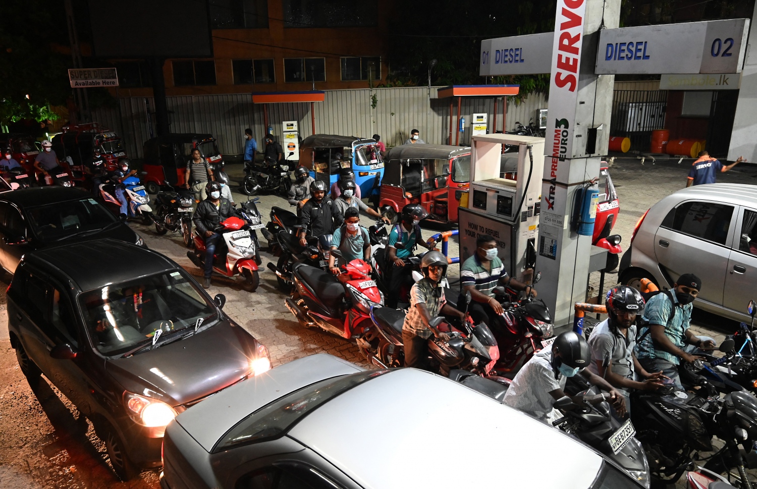 ކޮލަމްބޯ - މާޗް 20 - ސްރީ ލަންކާގެ ވެރިރަށް ކޮލަމްބޯގެ އައިއޯސީ ފިއުލް ސްޓޭޝަނުގެ ބޭރުގައި ވެހިކަލްތަކަށް ތެޔޮ އަޅަން ކިޔޫ ހަދާފައި: ލަންކާގައި ކައްކާ ގޭސް ނުލިބޭތީ ގިނަ މީހުން ކައްކަން މިހާރު ބޭނުން ކުރަނީ ކަރާސީން. --ފޮޓޯ:އޭއެފްޕީ