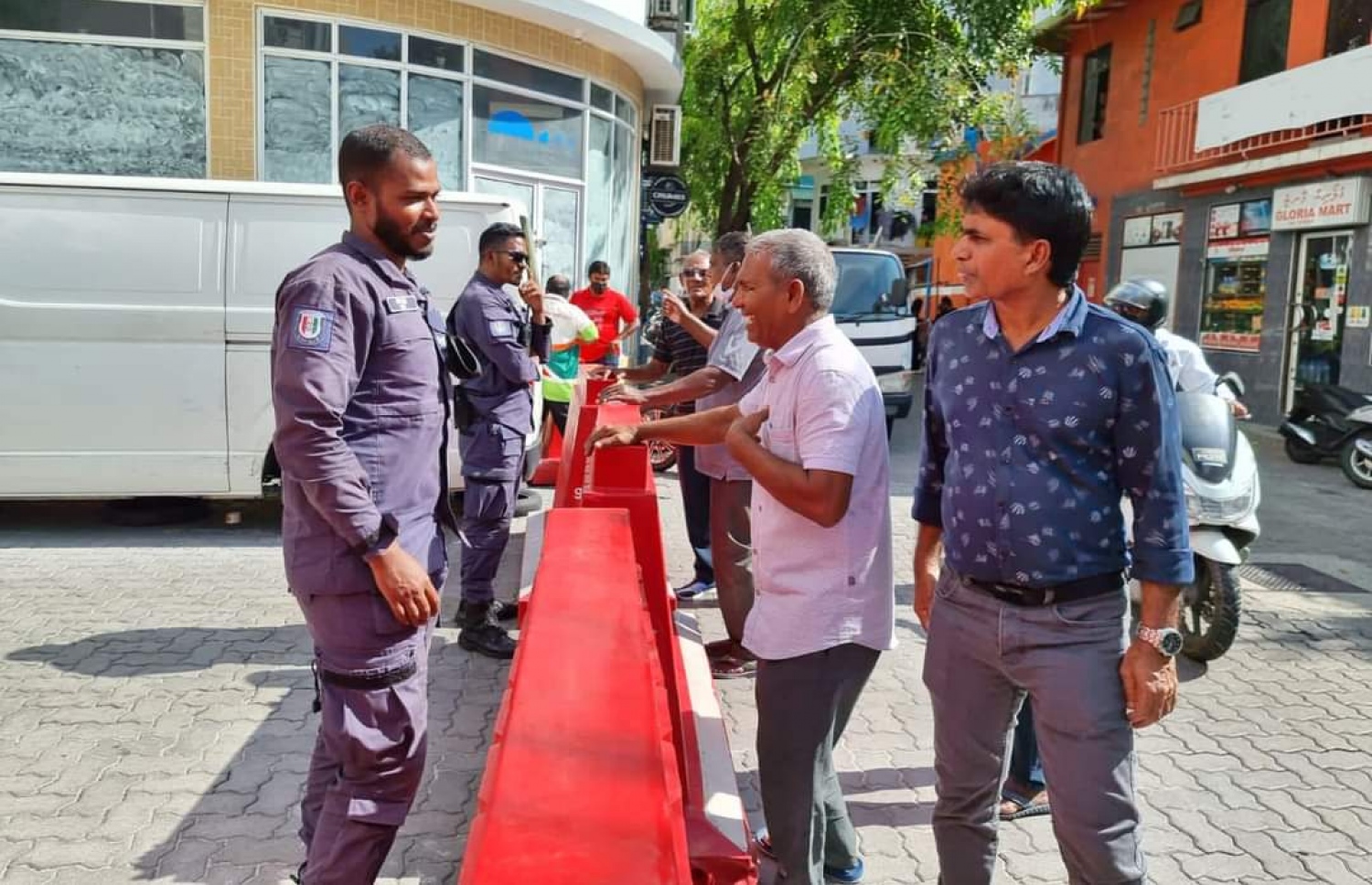 ޕީޕީއެމުން މާލޭގައި ބާއްވާ "އިންޑިއާ އައުޓް" މުޒާހަރާގެ ތެރެއިން ބެރިކޭޑުތަކުގެ ފަހަތުގައި ތިބި ބަޔަކު ފުލުހުންނާ ވާހަކަދައްކަނީ.-- ފޮޓޯ: ޕީޕީއެމް