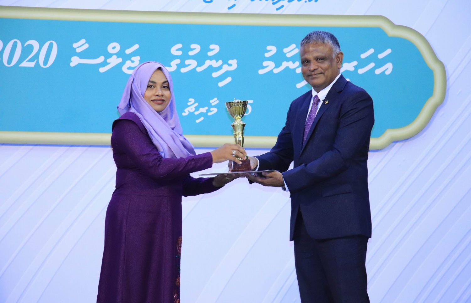 އަހުމަދިއްޔާ ސްކޫލުގެ އިނާމް ދިނުމުގެ ޖަލްސާގައި އެ ސްކޫލުގެ ޓީޗަރަކަށް އިނާމް ދެއްވަނީ -- ފޮޓޯ: އަހުމަދިއްޔާ ސްކޫލް