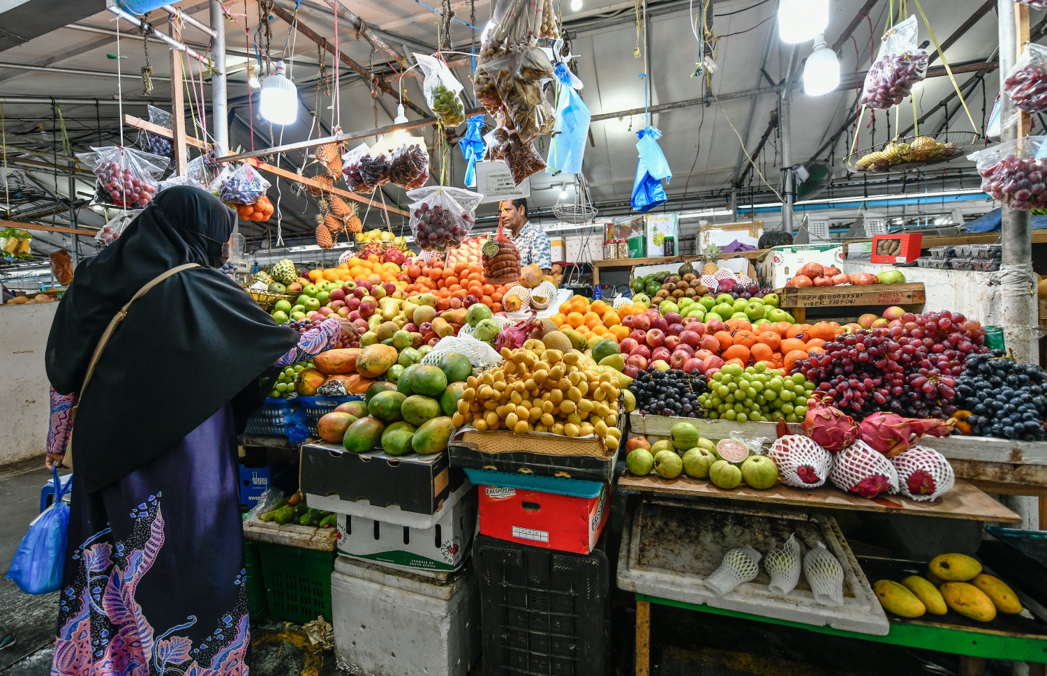 ލޯކަލް މާރުކޭޓުގައި ގޮޅިއަކުން މީހަކު މުދާ ގަންނަނީ. އެހެން ދުވަސްތަކެކޭ ހިލާފަށް މި ދުވަސްވަރު މާޒާރުމަތި ފެންނަނީ ހަލަބޮލިކޮށް.--- ފޮޓޯ: ނިޝާން އަލީ | މިހާރު