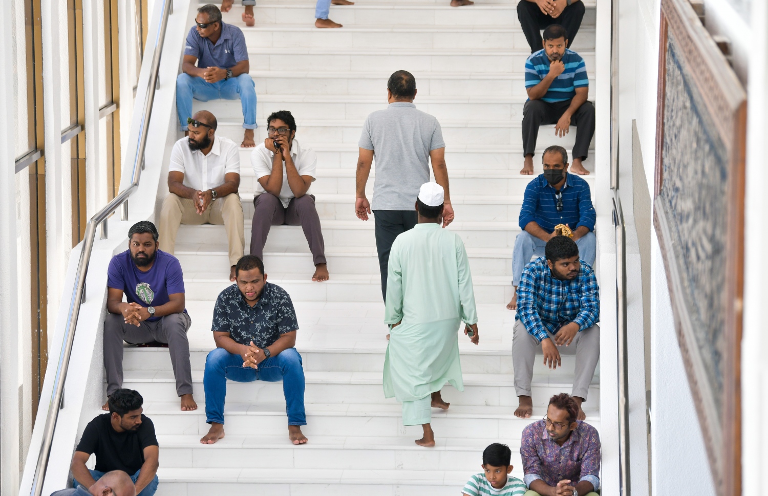 އިސްލާމީ މަރުކަޒުގައި މިއަދު ކުރި ހުކުރު ނަމާދުގައި ހުތުބާ އަޑުއަހަން ބަޔަކު ސިޑިމަތީގައި އިށީނދެގެން ތިބިއިރު، ދެ މީހަކު ސިޑިން އަރަނީ.--- ފޮޓޯ: ފަޔާޒު މޫސާ | މިހާރު