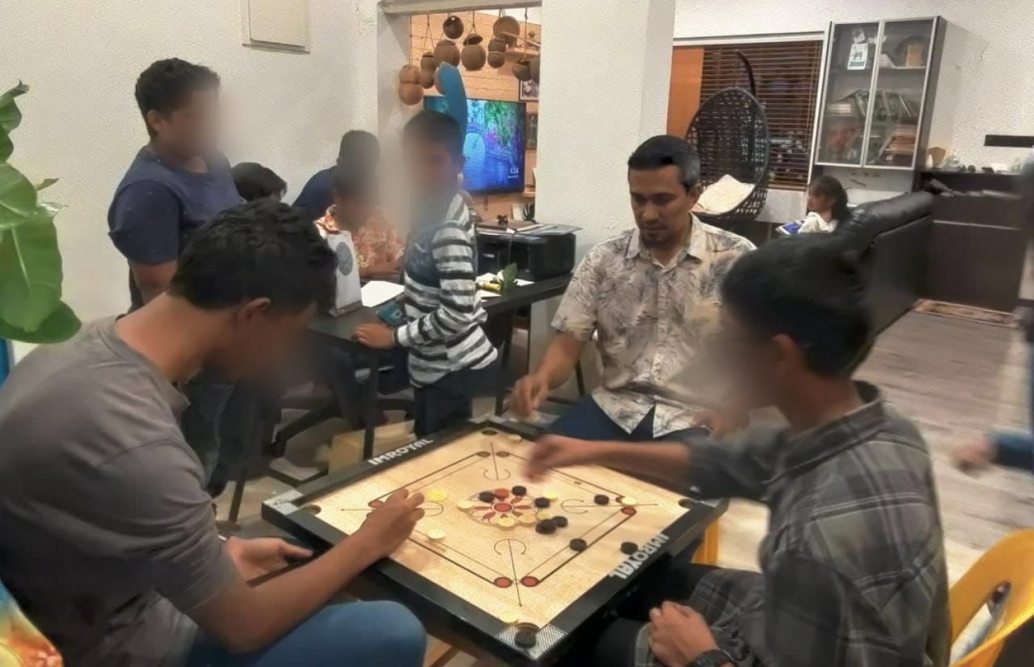 ފުވައްމުލަކު މޭޔަރު، އެ ރަށުގެ އަމާން ވެށީގެ ކުދިންނާ އެކު ކެރަމް ކުޅުއްވަނީ.