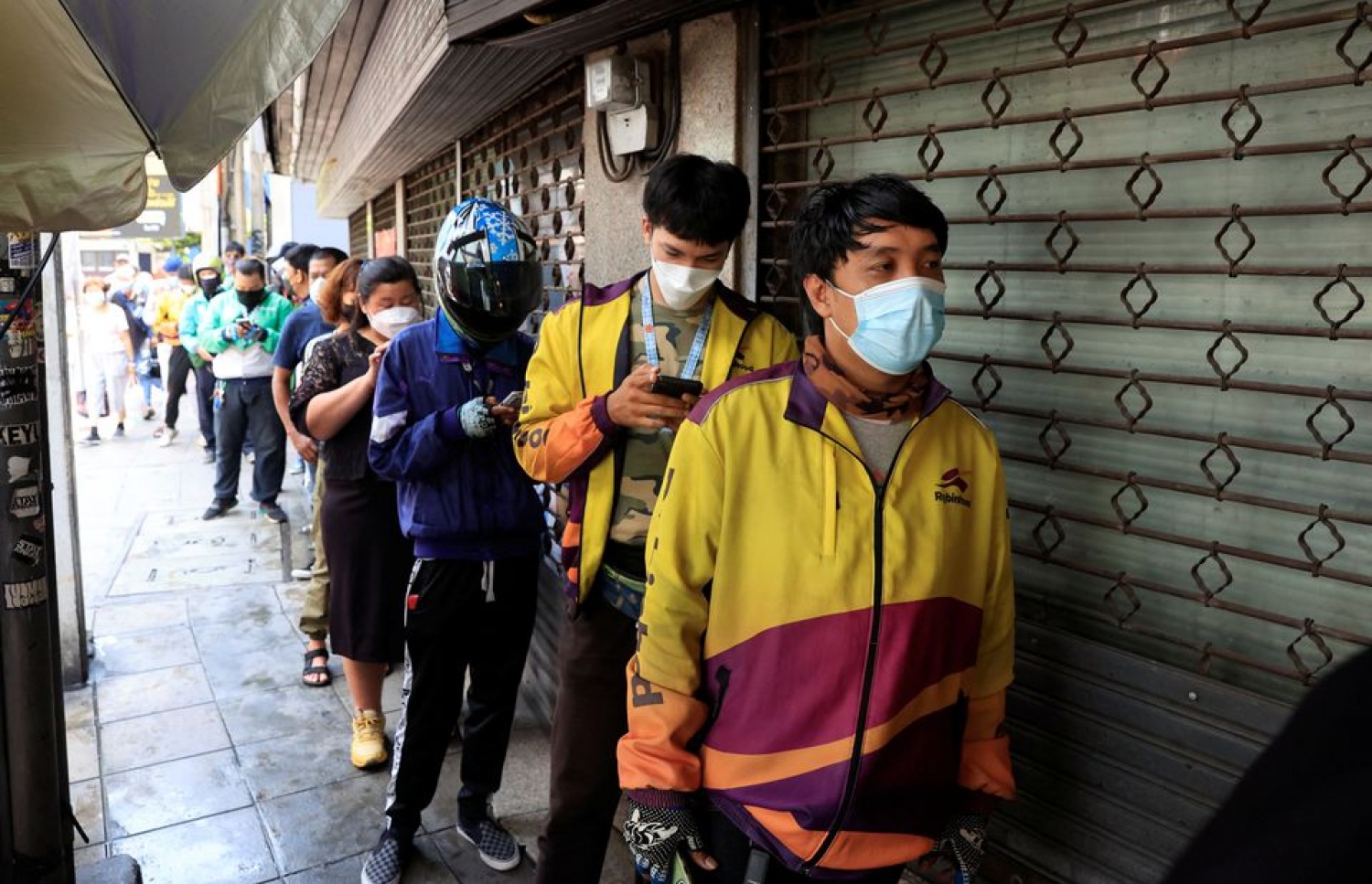 މެންގޯ ސްޓިކީ ރައިސްގައި ގަންނަން ބެންކޮކްގެ ފިހާރަތަކުގެ ބޭރުގައި މީހުން ކިއު ހަދައިގެން -- ފޮޓޯ: ރޮއިޓާސް