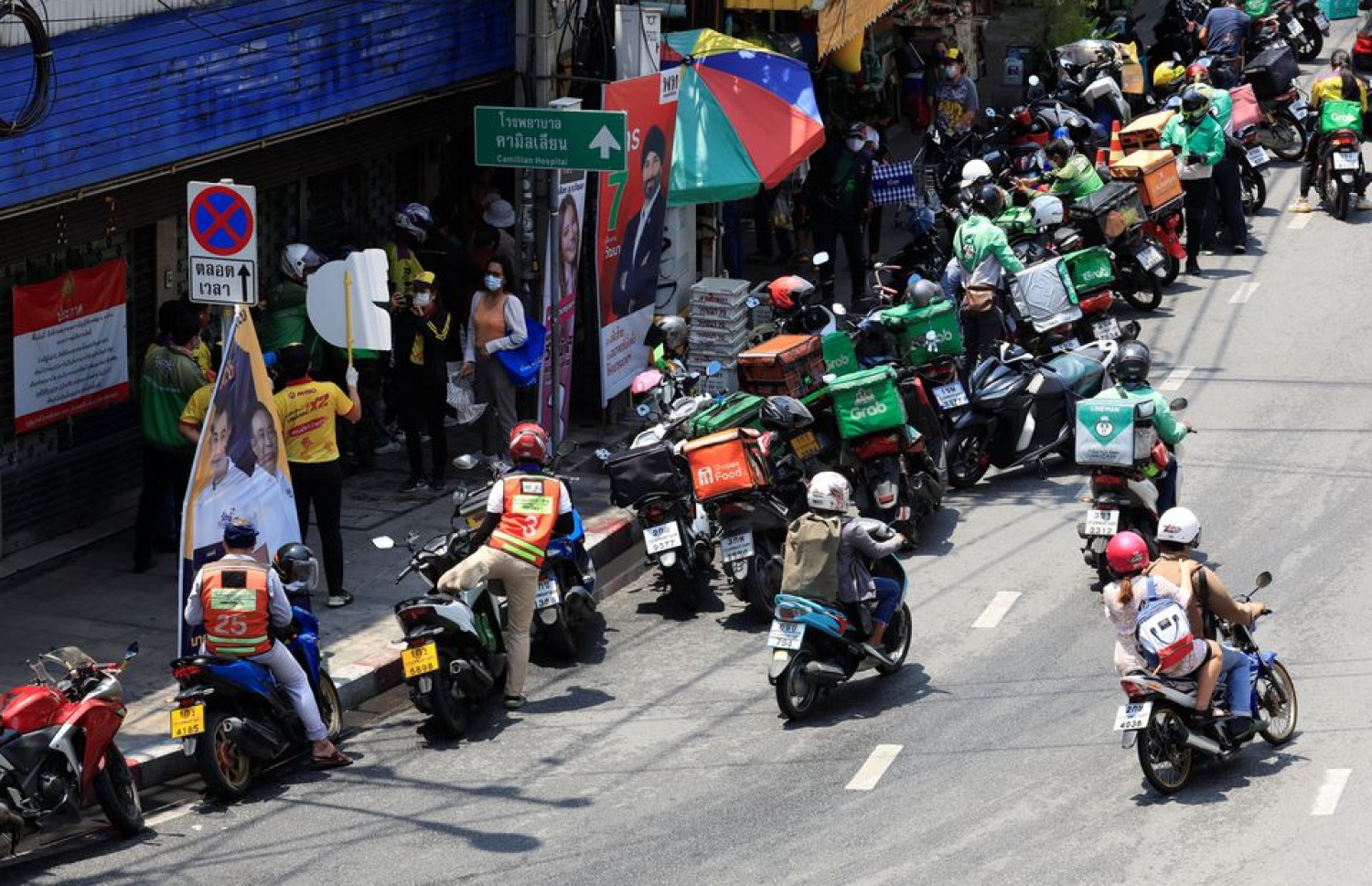 މެންގޯ ސްޓިކީ ރައިސް ޑެލިވަރީ ކުރާ މީހުން އޯޑަރު ބަލާ ގޮސް، ބެންކޮކްގެ މަގެއްގައި -- ފޮޓޯ: ރޮއިޓާސް