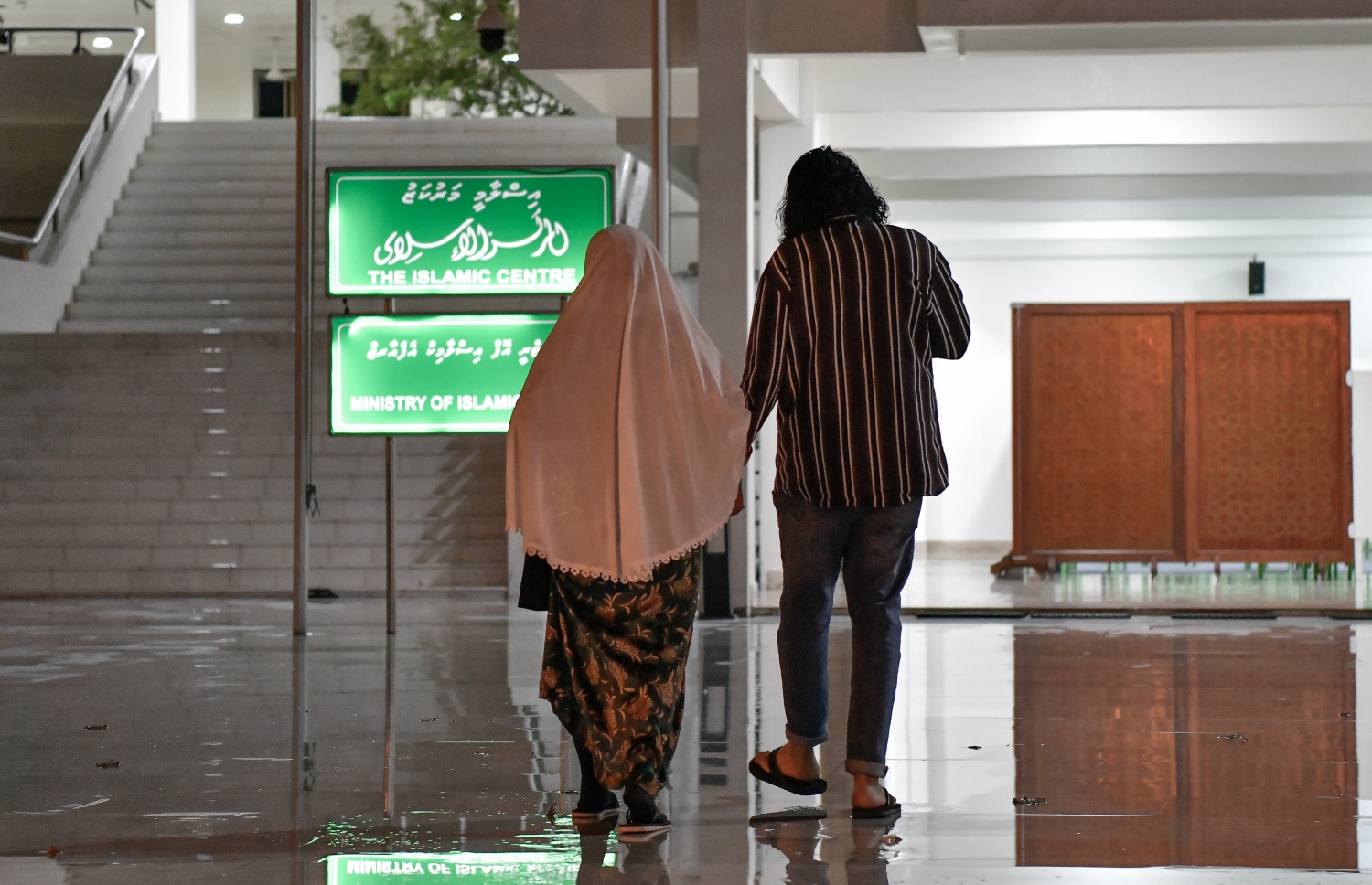 ދަމުނަމާދަށް ދިޔަ މީހަކު އާއިލާގެ ދުވަސްވީ މީހެއްގެ އަތުގައި ހިފައިގެން މިސްކިތަށް ވަންނަނީ. -- ފޮޓޯ: ނިޝާން އަލީ/މިހާރު