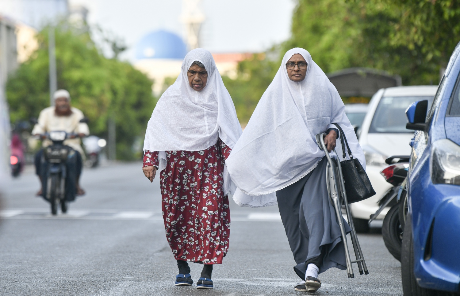 ހުޅުމާލޭގެ ސްޓޭޑިއަމް ސަރަހައްދުގައި ކުރި ފިތުރު އީދު ނަމާދުގެ ބޮޑު ޖަމާއަތަށް ދެ އަންހެނަކު ދަނީ: އީދު ނަމާދުގައި ބައިވެރިވާން ވަރަށް ގިނަ އަންހެނުން އިސްކަންދޭކަން ފާހަގަކުރެވޭ.---ފޮޓޯ: ނިޝާން އަލީ| މިހާރު