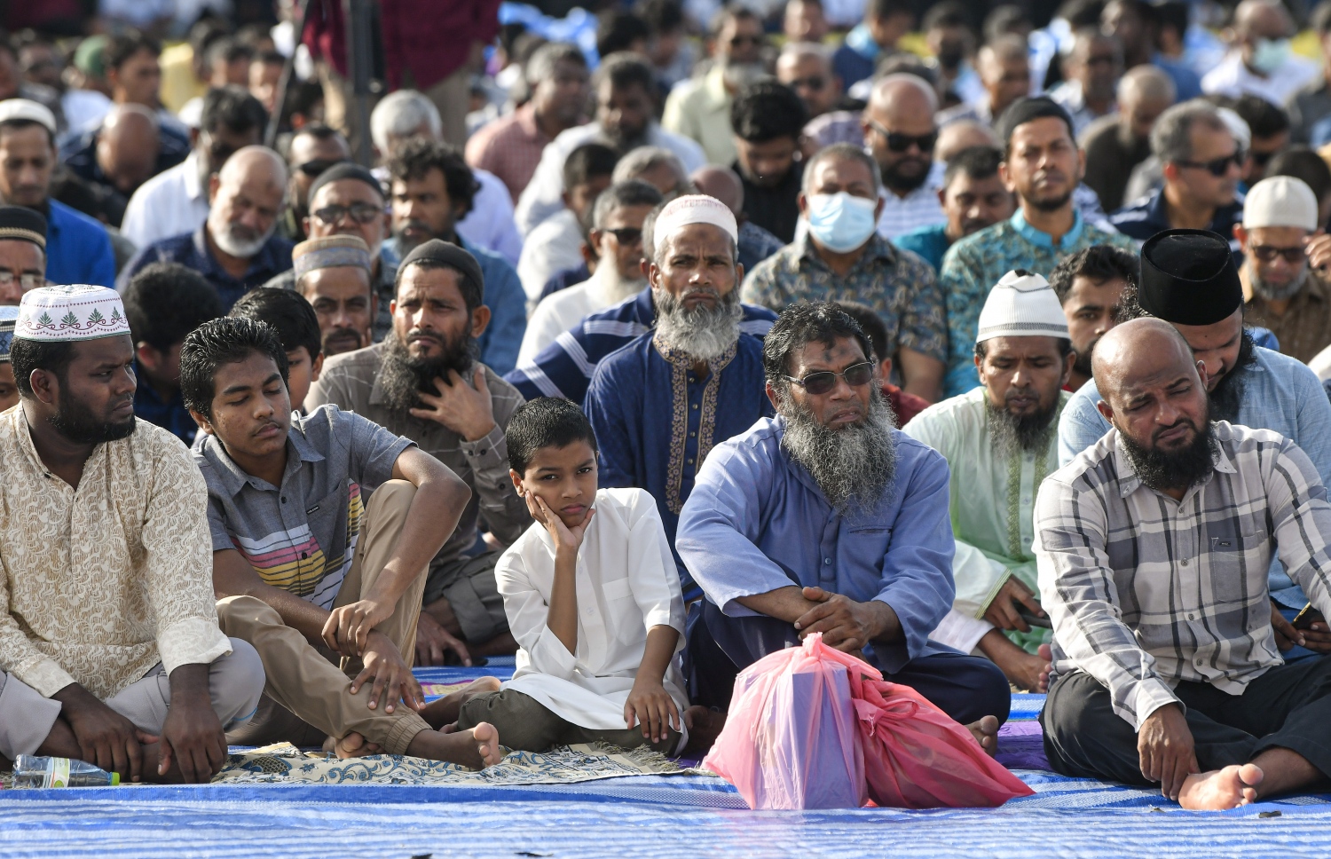 ހުޅުމާލޭގެ ސްޓޭޑިއަމް ސަރަހައްދުގައި ހެދި ބޮޑު ޖަމާއަތަށް ފިތުރު އީދު ނަމާދަށް ދިޔަ މީހުން އިށީނދެގެން: ދެ އަހަރުގެ މެދުކެނޑުމަކަށް ފަހު އީދު ނަމާދު ކުރުމުން ގިނަ ބަޔަކު އެ އަޅުކަމުގައި ބައިވެރިވި.---ފޮޓޯ: ނިޝާން އަލީ| މިހާރު