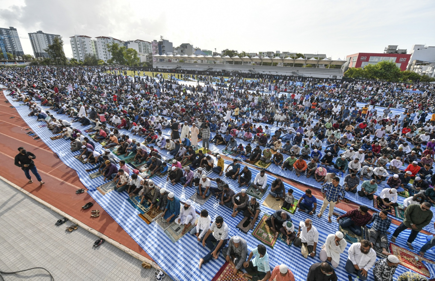 ހުޅުމާލޭގެ ސްޓޭޑިއަމް ސަރަހައްދުގައި ހެދި ބޮޑު ޖަމާއަތަށް ފިތުރު އީދު ނަމާދަށް ދިޔަ މީހުން އިށީނދެގެން: ދެ އަހަރުގެ މެދުކެނޑުމަކަށް ފަހު އީދު ނަމާދު ކުރުމުން ގިނަ ބަޔަކު އެ އަޅުކަމުގައި ބައިވެރިވި.---ފޮޓޯ: ނިޝާން އަލީ| މިހާރު