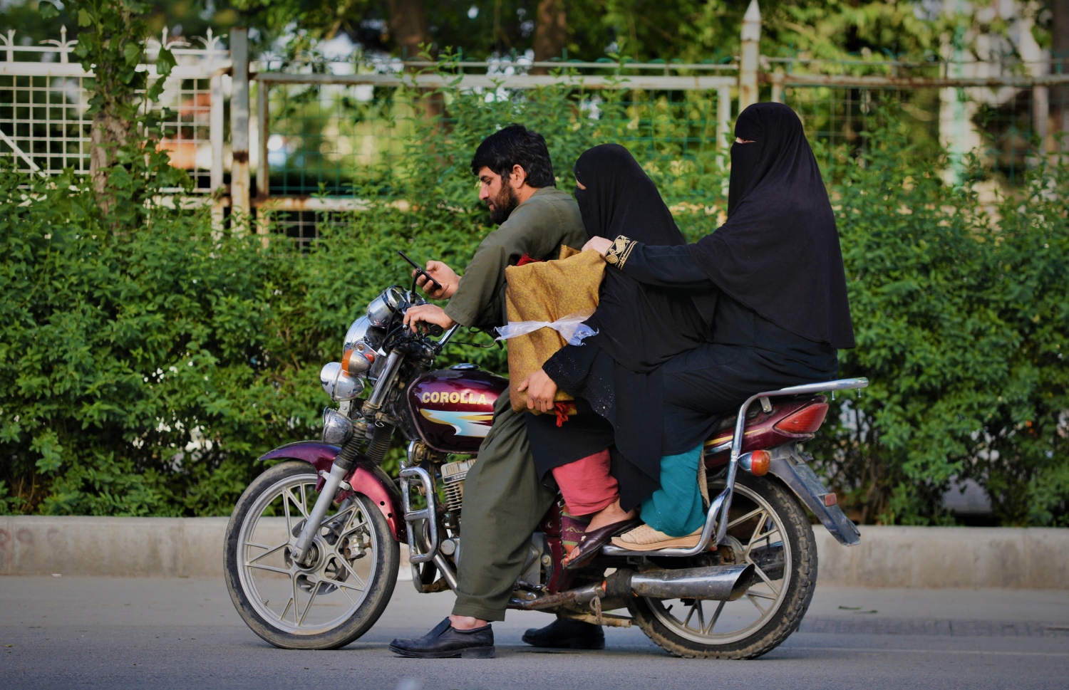 މެއި 7، 2022: މޫނު ބުރުގާ އެޅި ދެ އަންހެނަކު ސައިކަލަކަށް އަރުވައިގެން ފިރިހެނަކު ކާބުލްގެ މަގަކުން ސައިކަލުގައި ދުއްވަނީ. --އޭއެފްޕީ